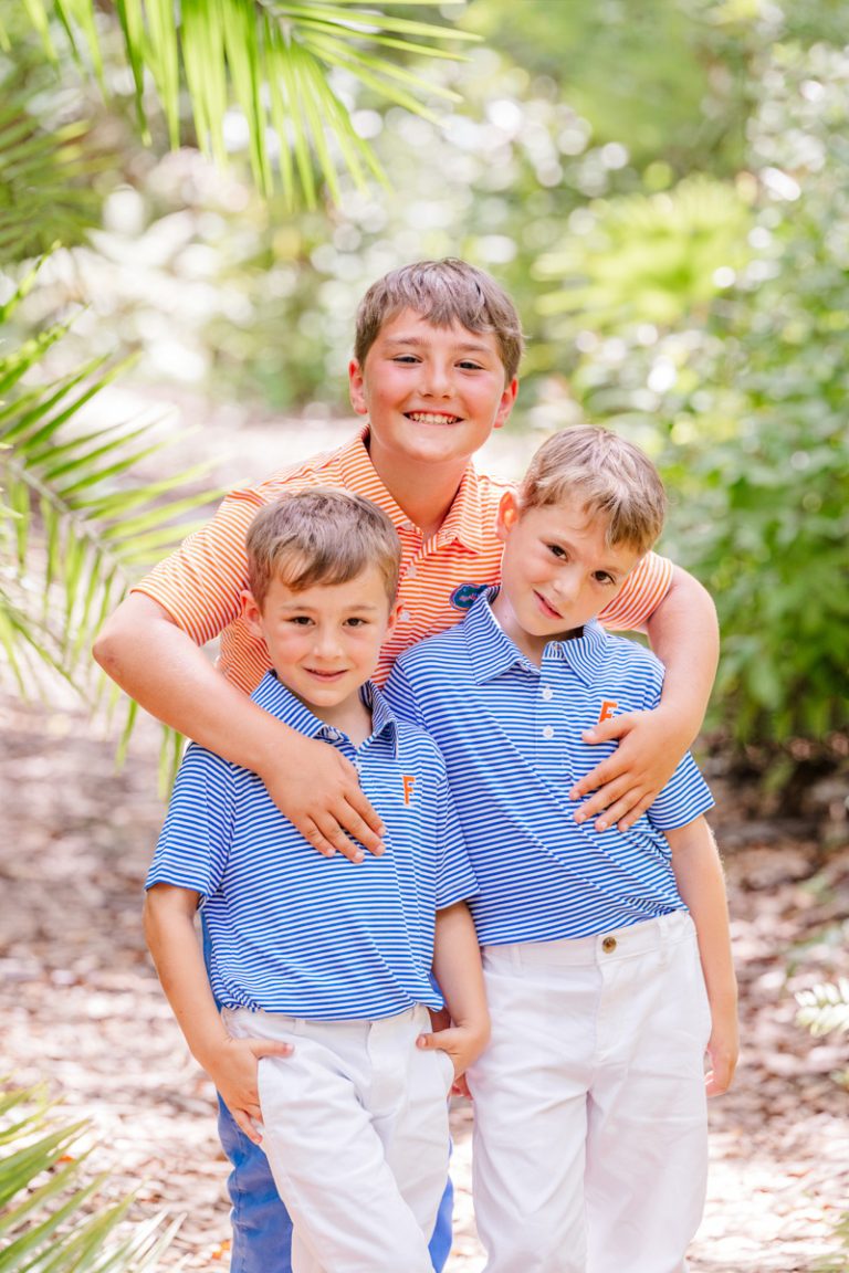 Older brother hugging younger siblings in the Florida Tech botanical gardesn