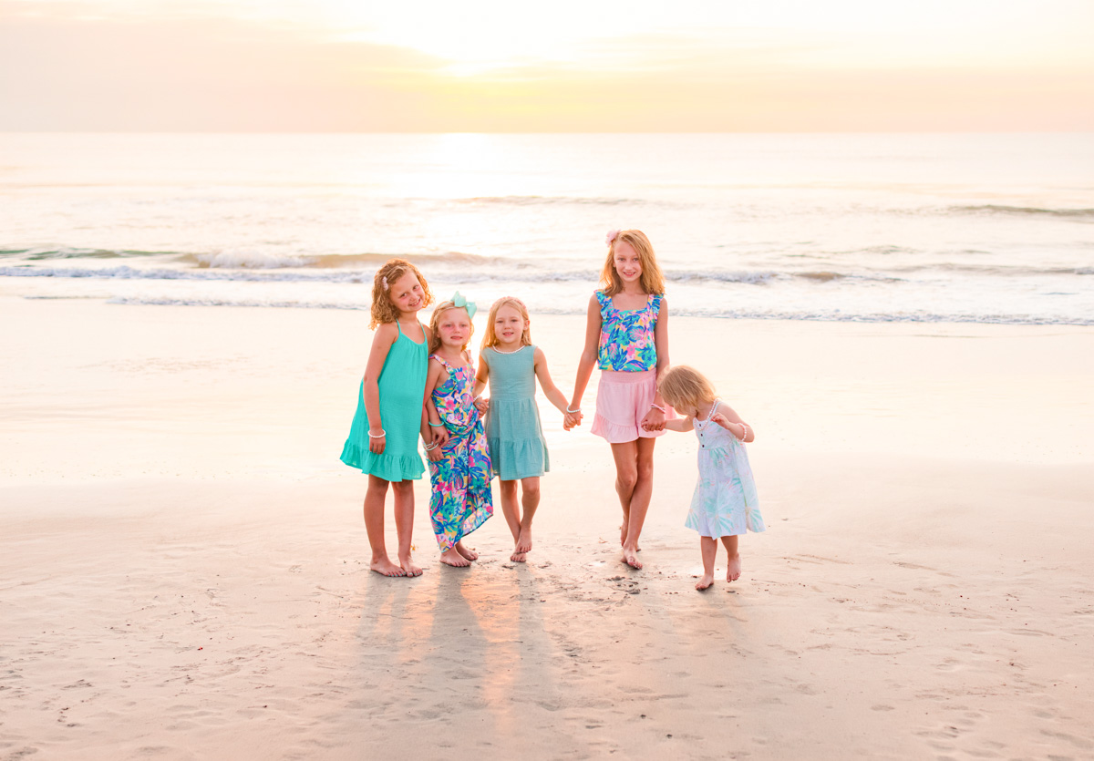 Five kids holding hands on Melbourne Beach during their family sunrise session