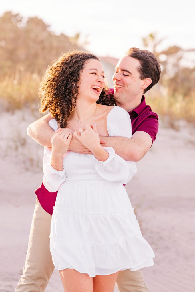 Man hugging women from behind on the beach