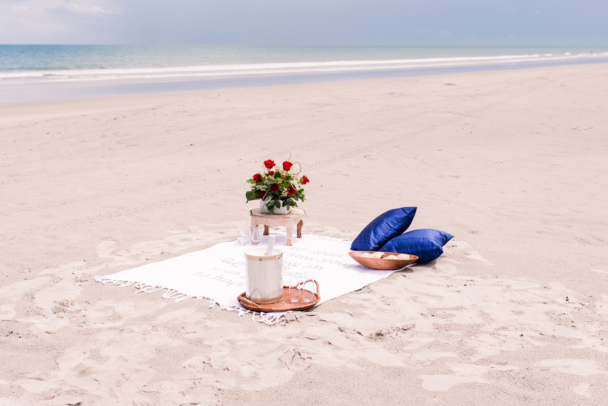 blanket and flowers and champagne set up on Melbourne beach for a proposal