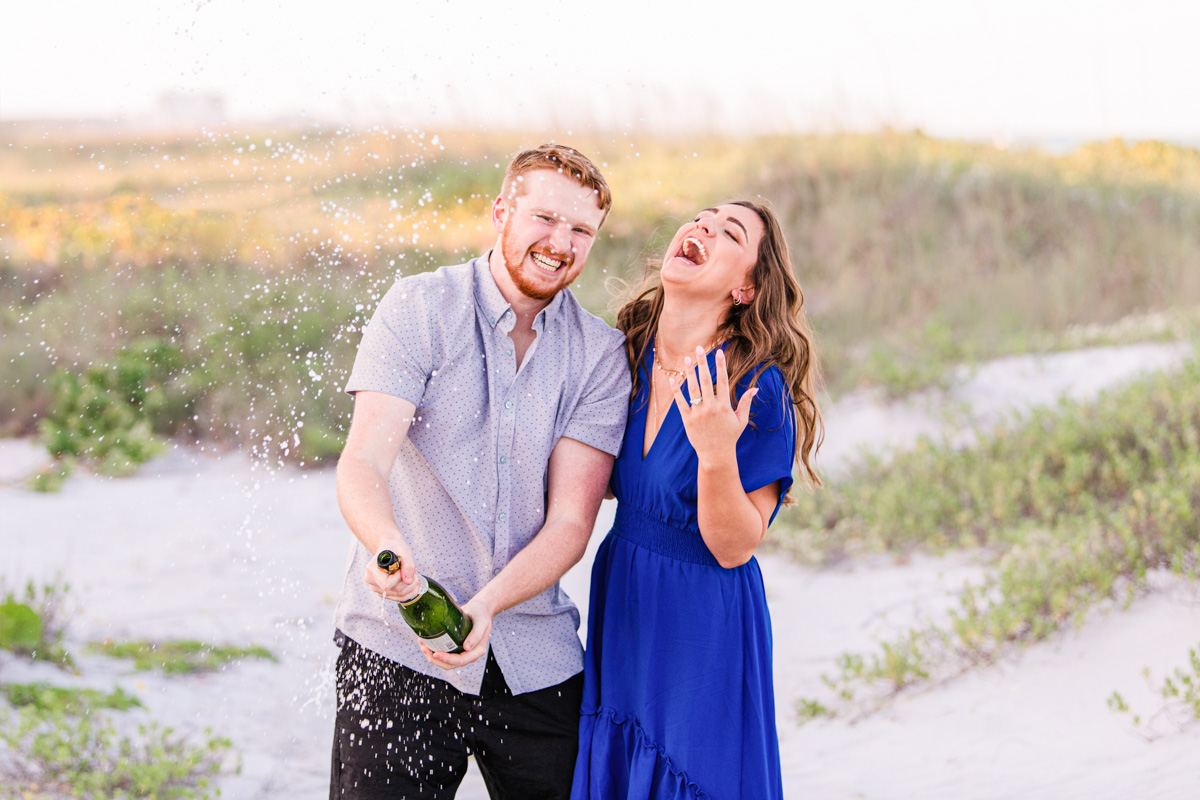 man popping champagne after proposal on melbourne bea