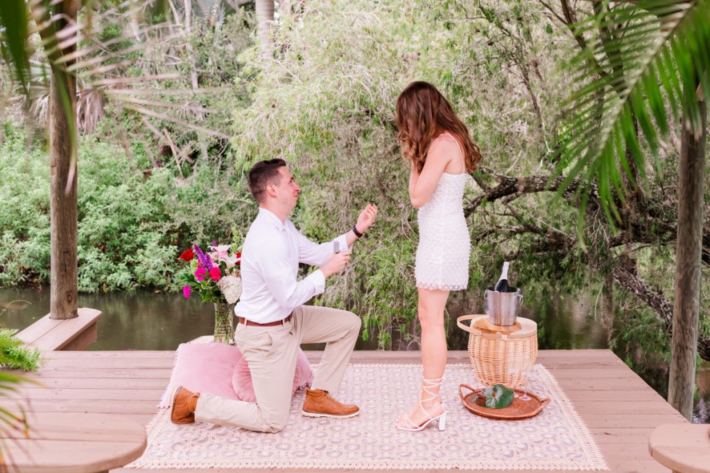 Groom down on one knee proposing to woman at Up the Creek Farms