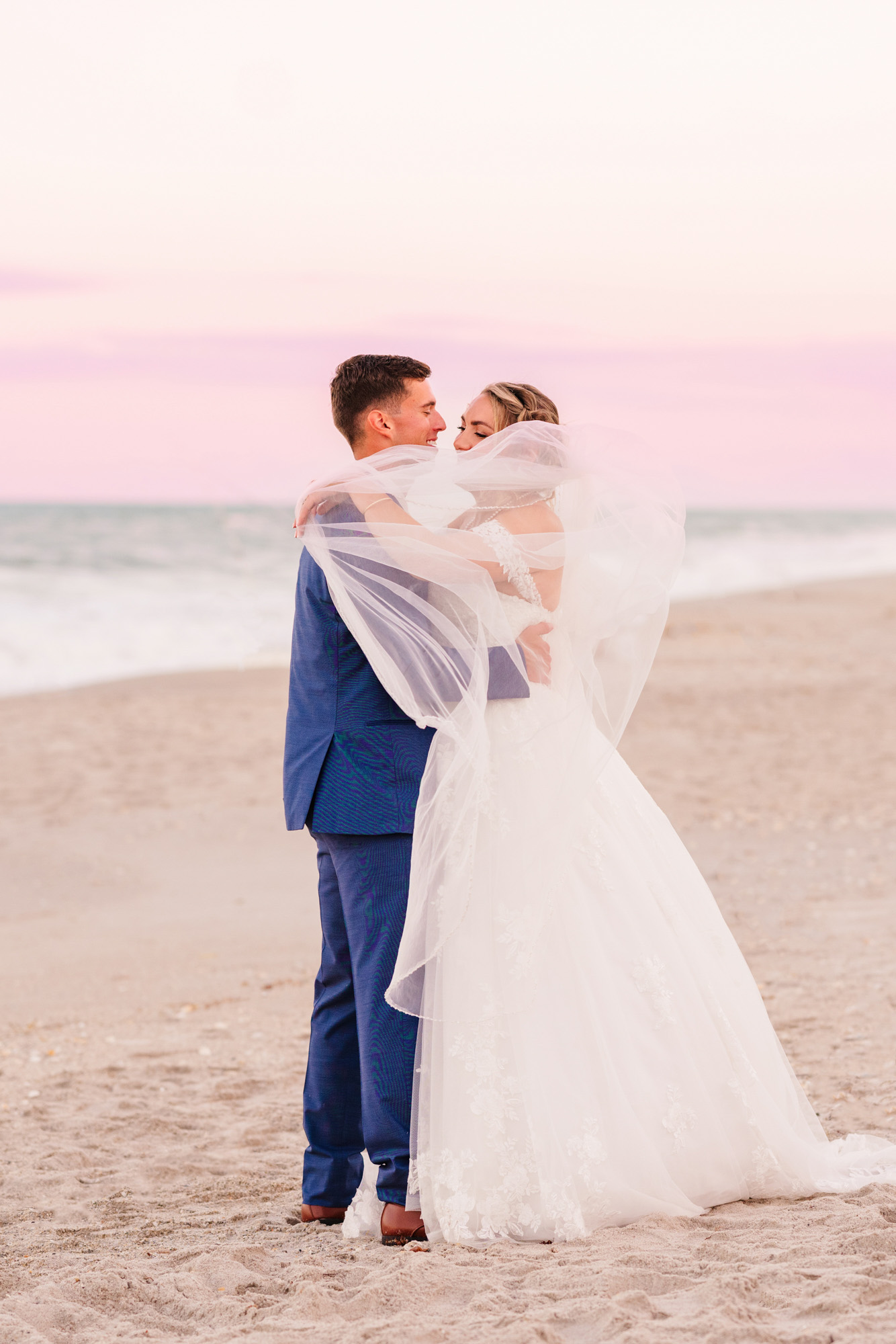 bride covering herself and groom with veil
