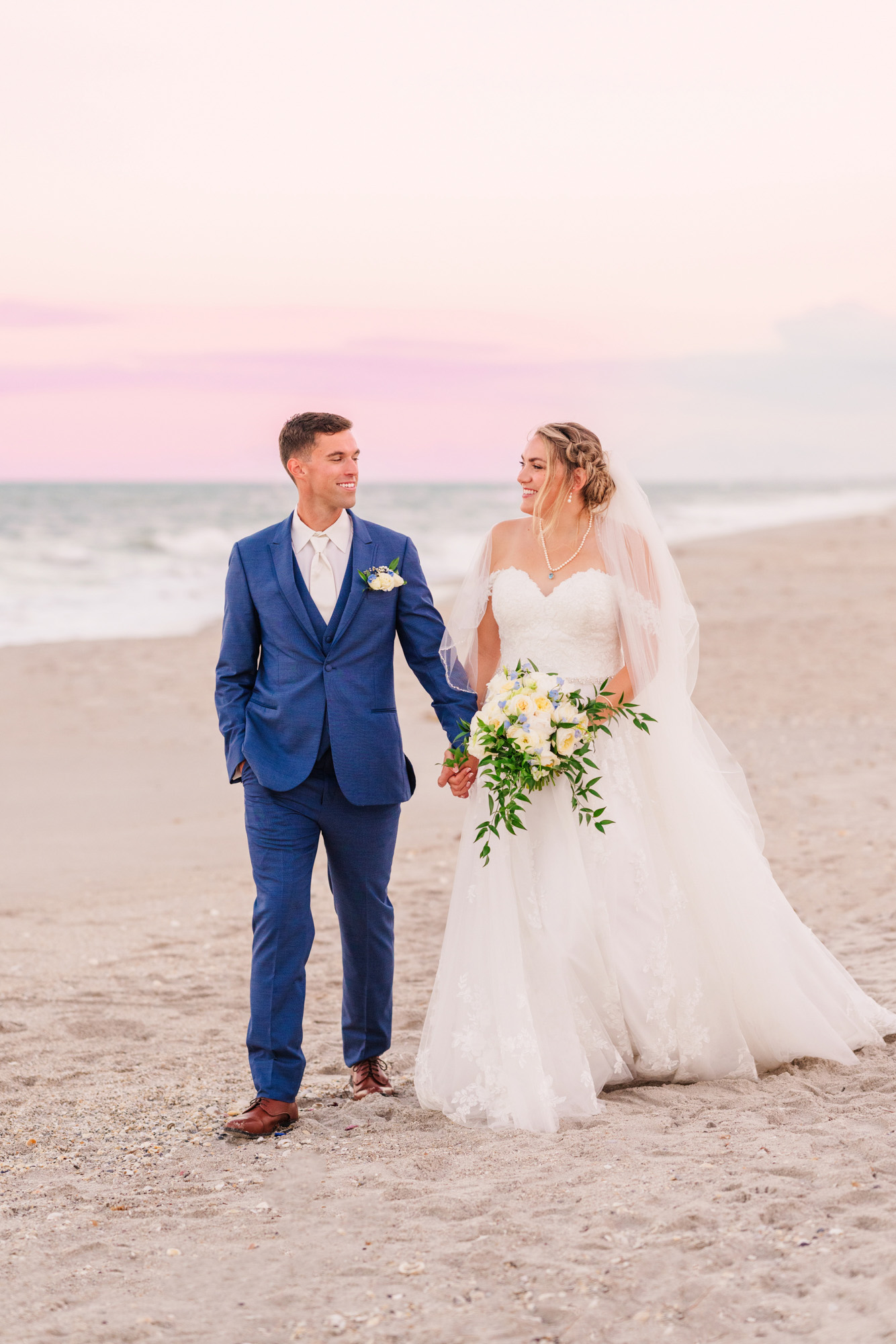 bride and groom walking down the beach after their wedding