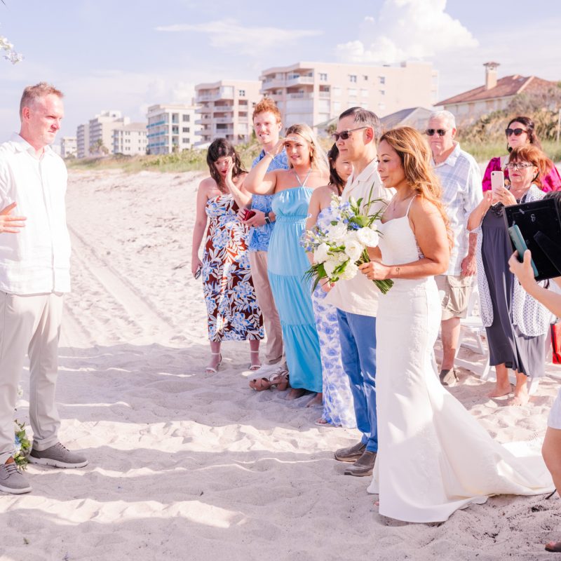 bride standing at the end of the aisle looking at the groom
