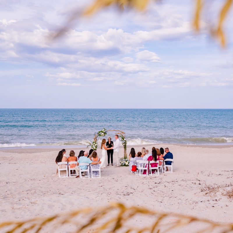 view of beach ceremony looking through the dunes