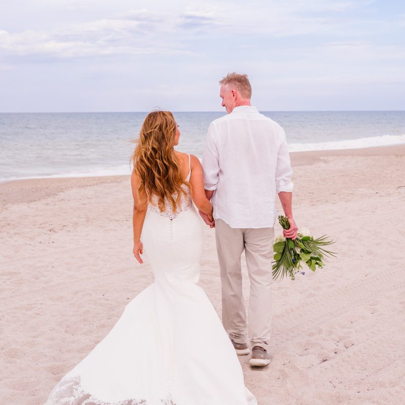 Couple walking away down the beach