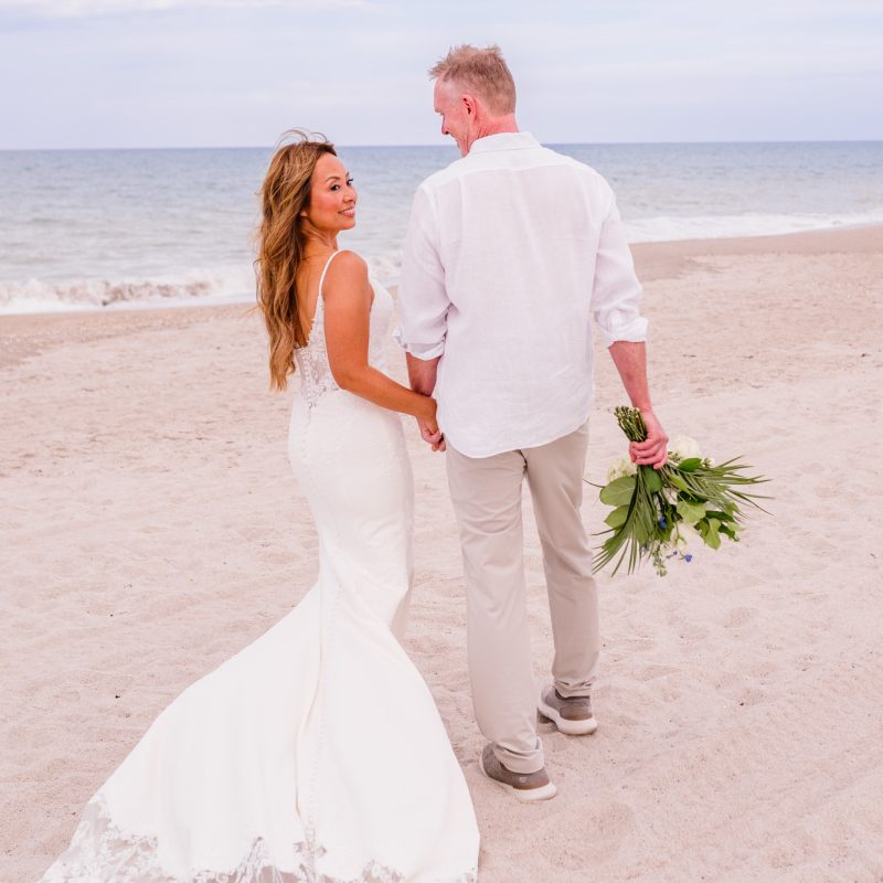 Couple walking away while looking back