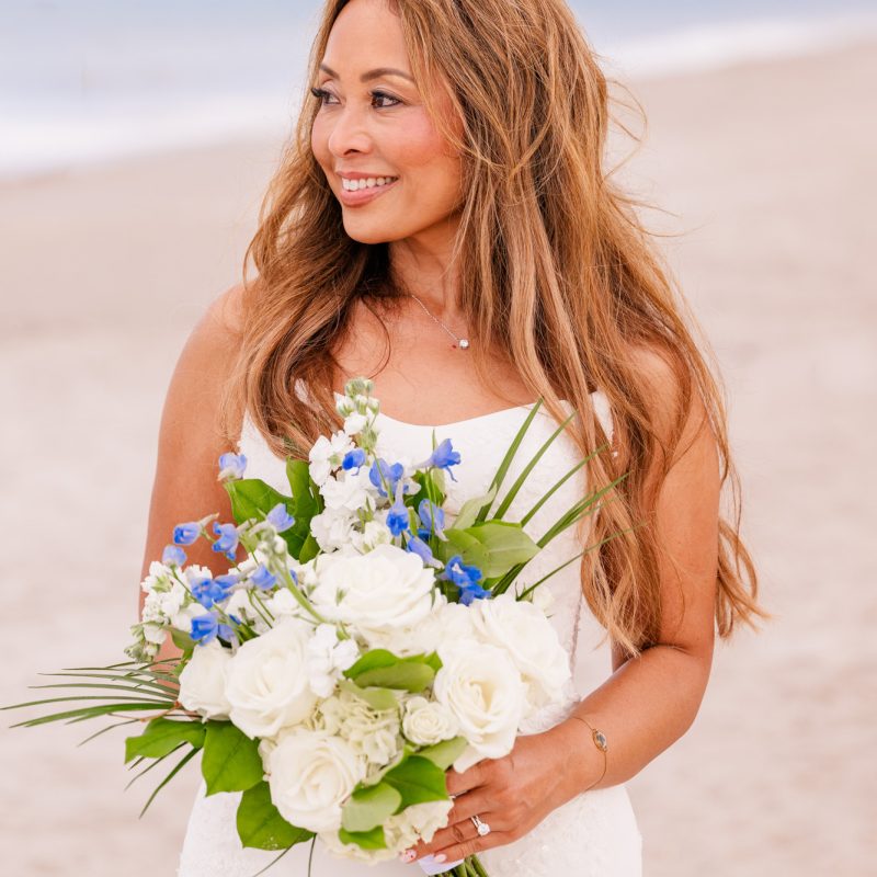 bride holding bouquet on the beach