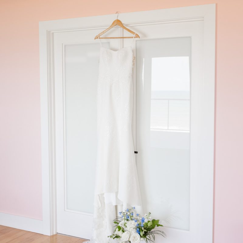 wedding dress hanging on the back of a door