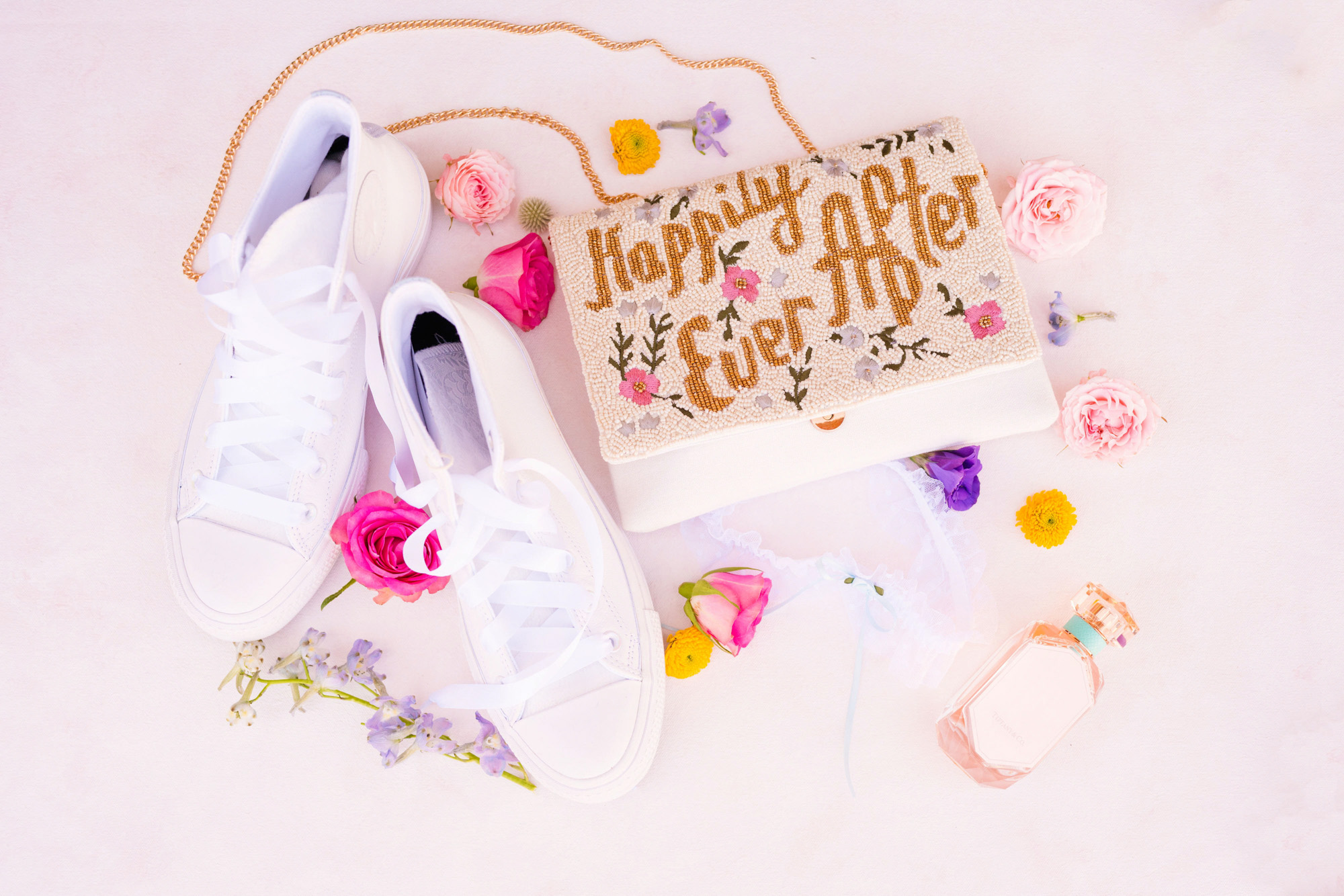 details of shoes and wedding purse shown on a pink background