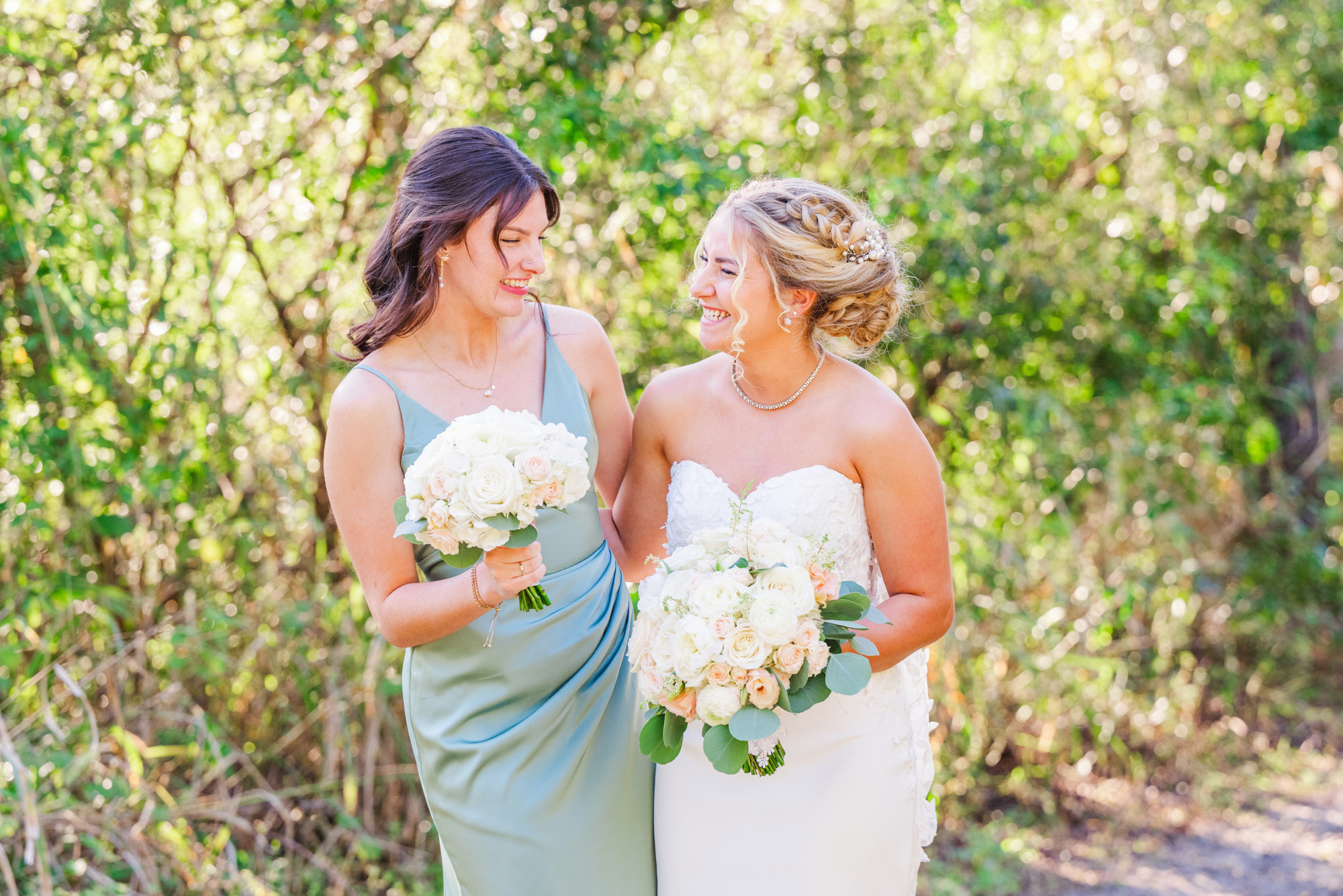 bride and bridesmaid in green laughing together