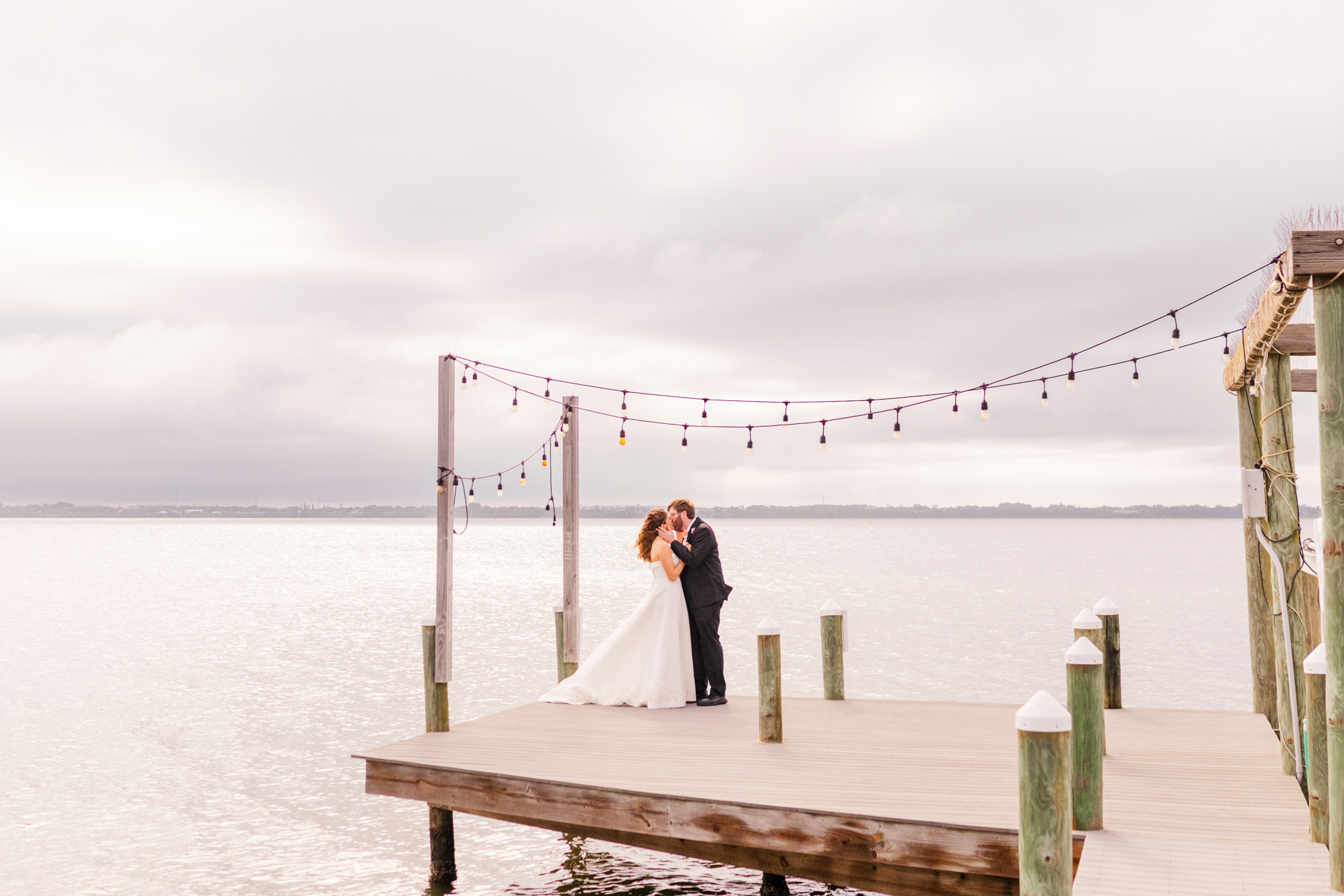 Bride and groom hugging on dock in Melbourne Beach