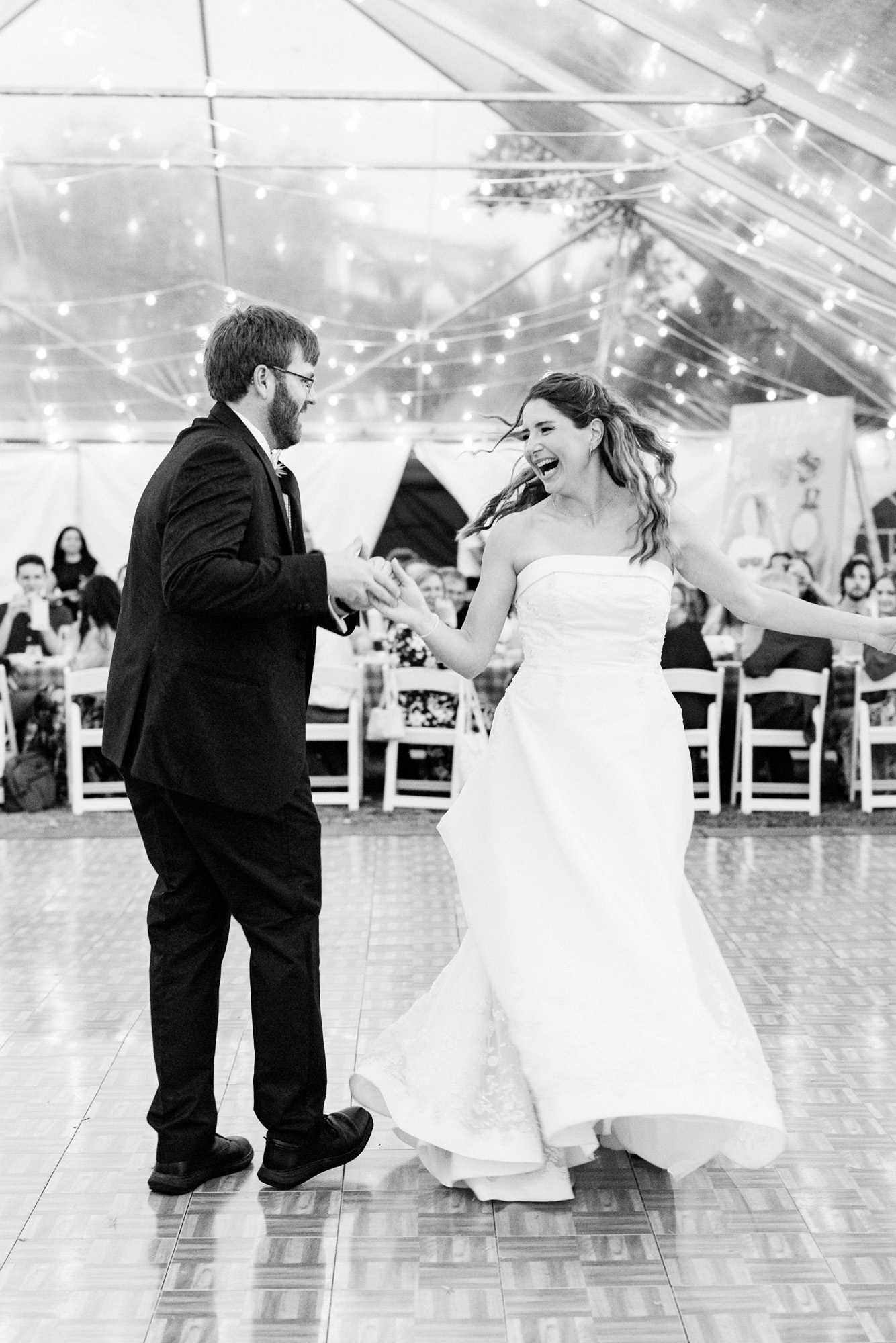 bride and groom laughing while dancing