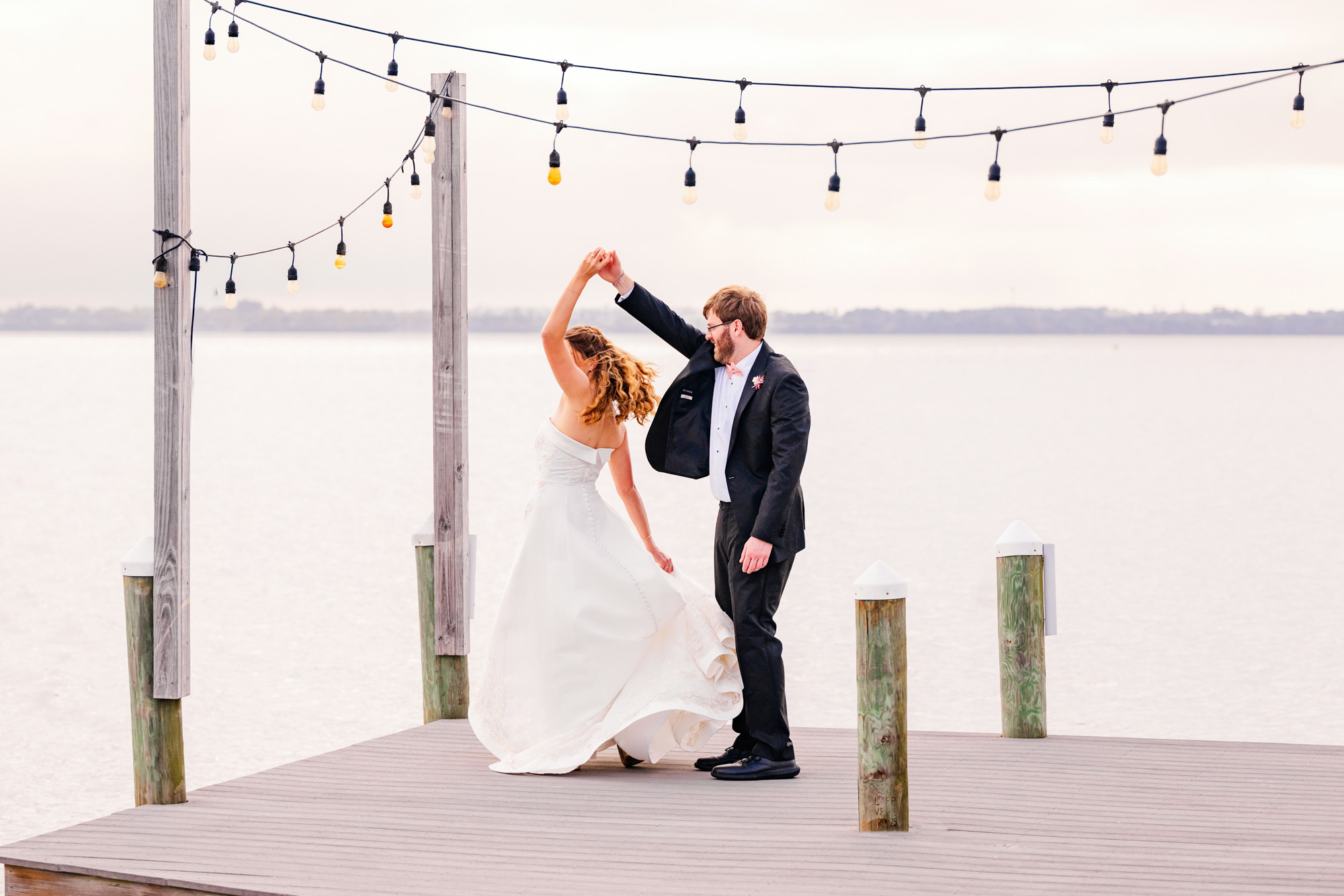 Groom twirling bride at the end of a dock in Melbourne Beach