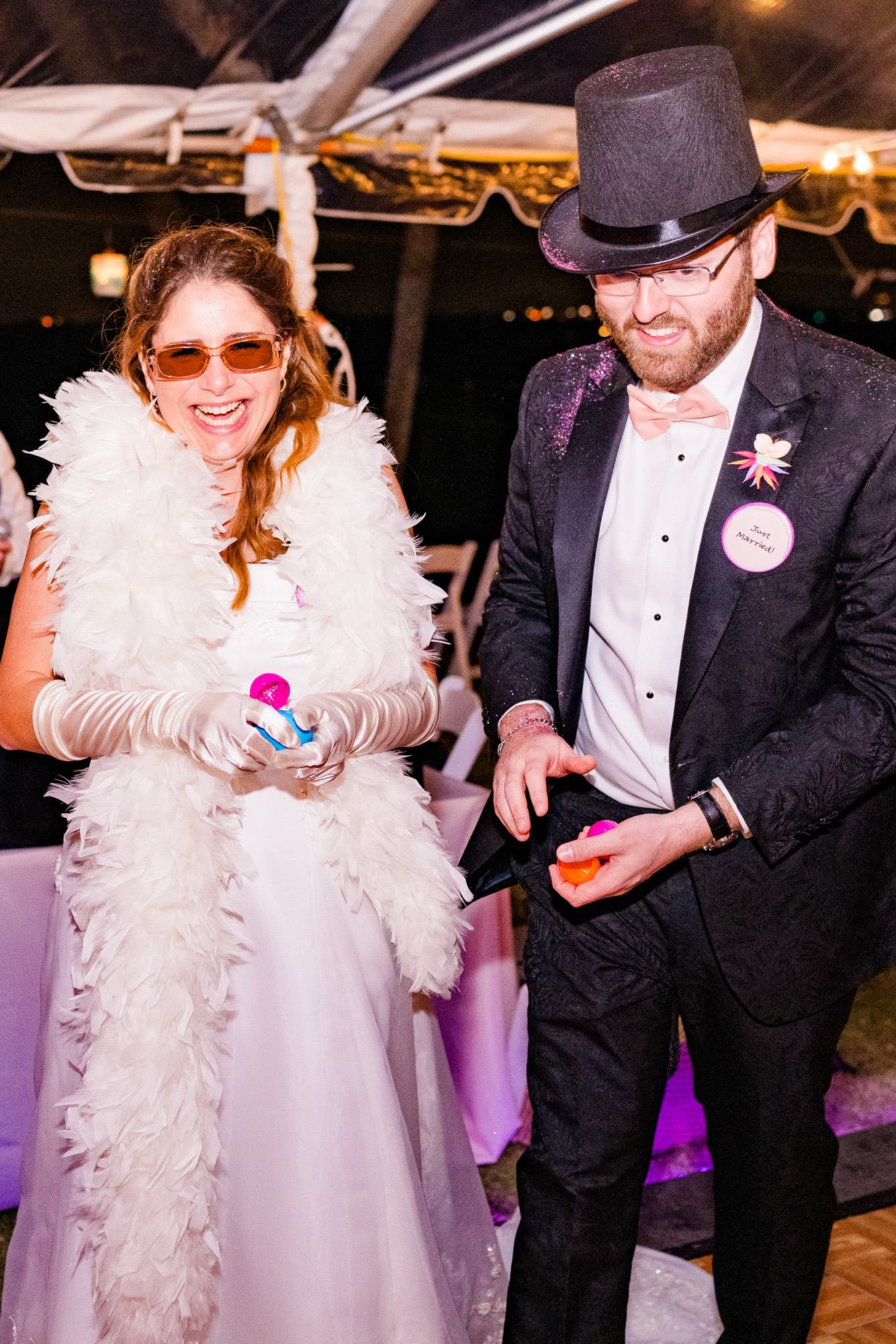 Bride and groom dressed in fuzzy boa and top hat