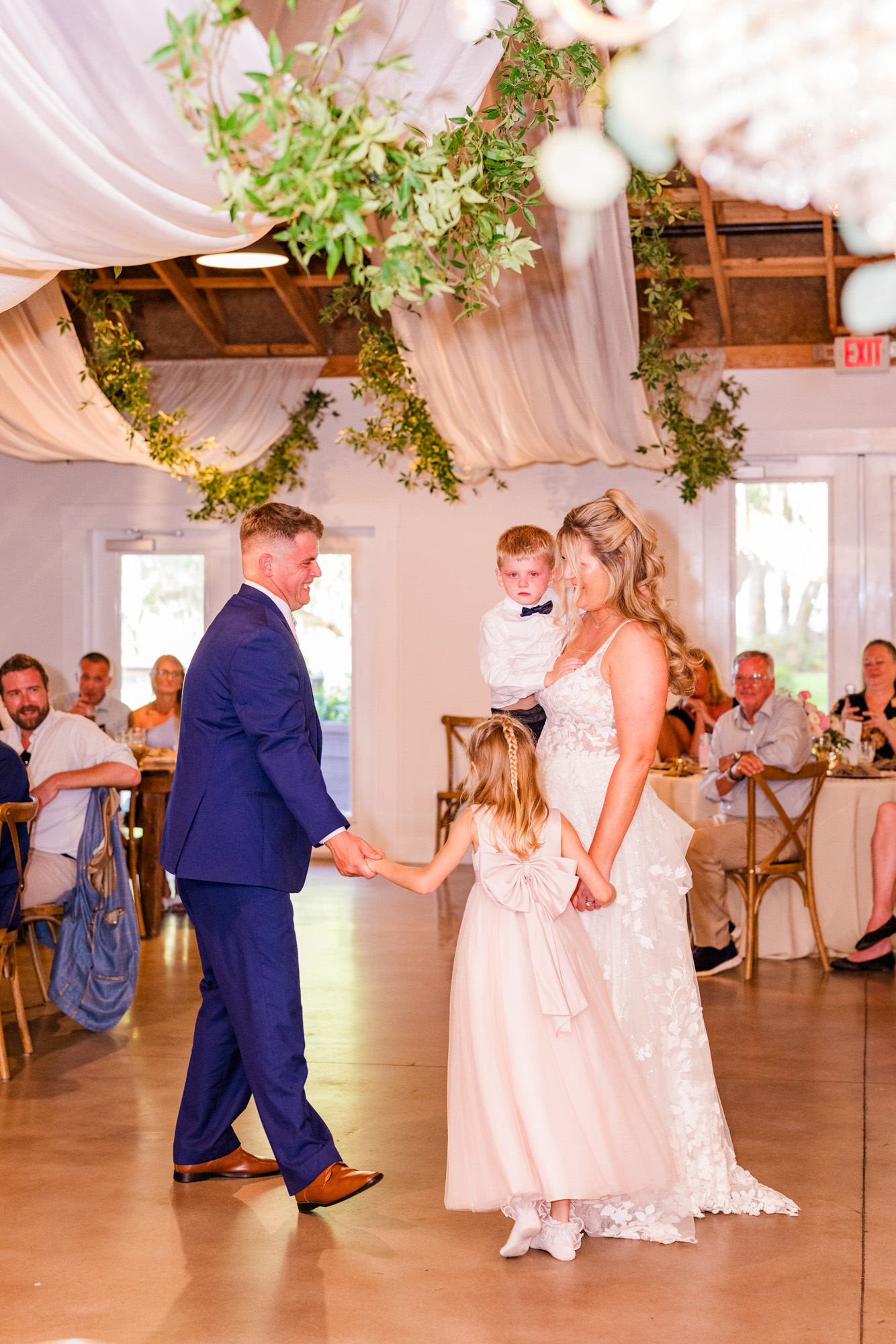 Bride and groom with their children during their first dance at Up the Creek Farms