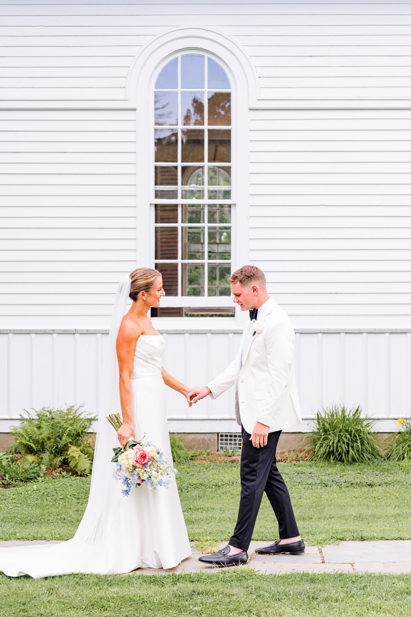 Bride and groom laughing during their first look outside Christ Church on Quaker Hill