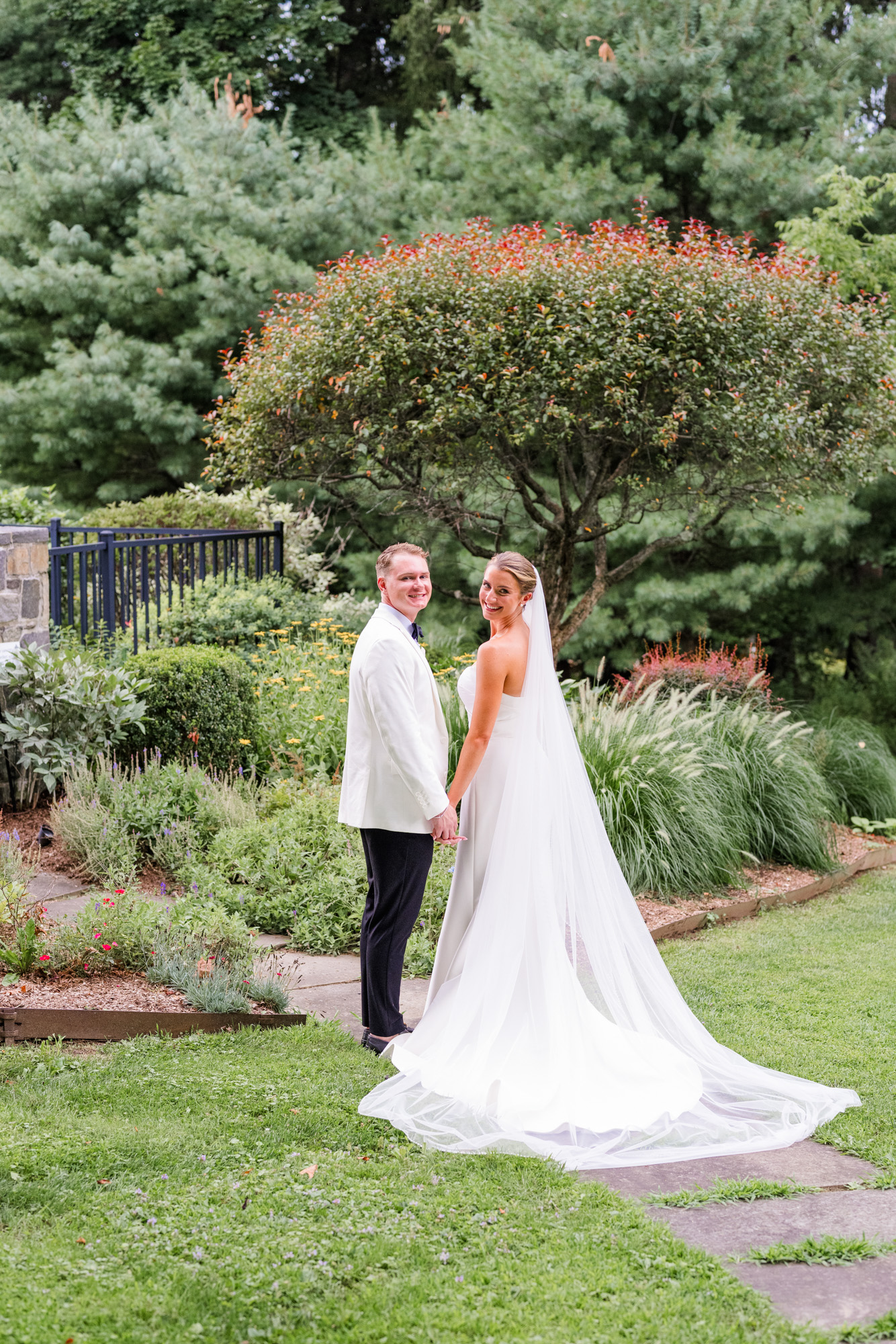 Bride and groom holding hands during their first look at a summer Pawling wedding
