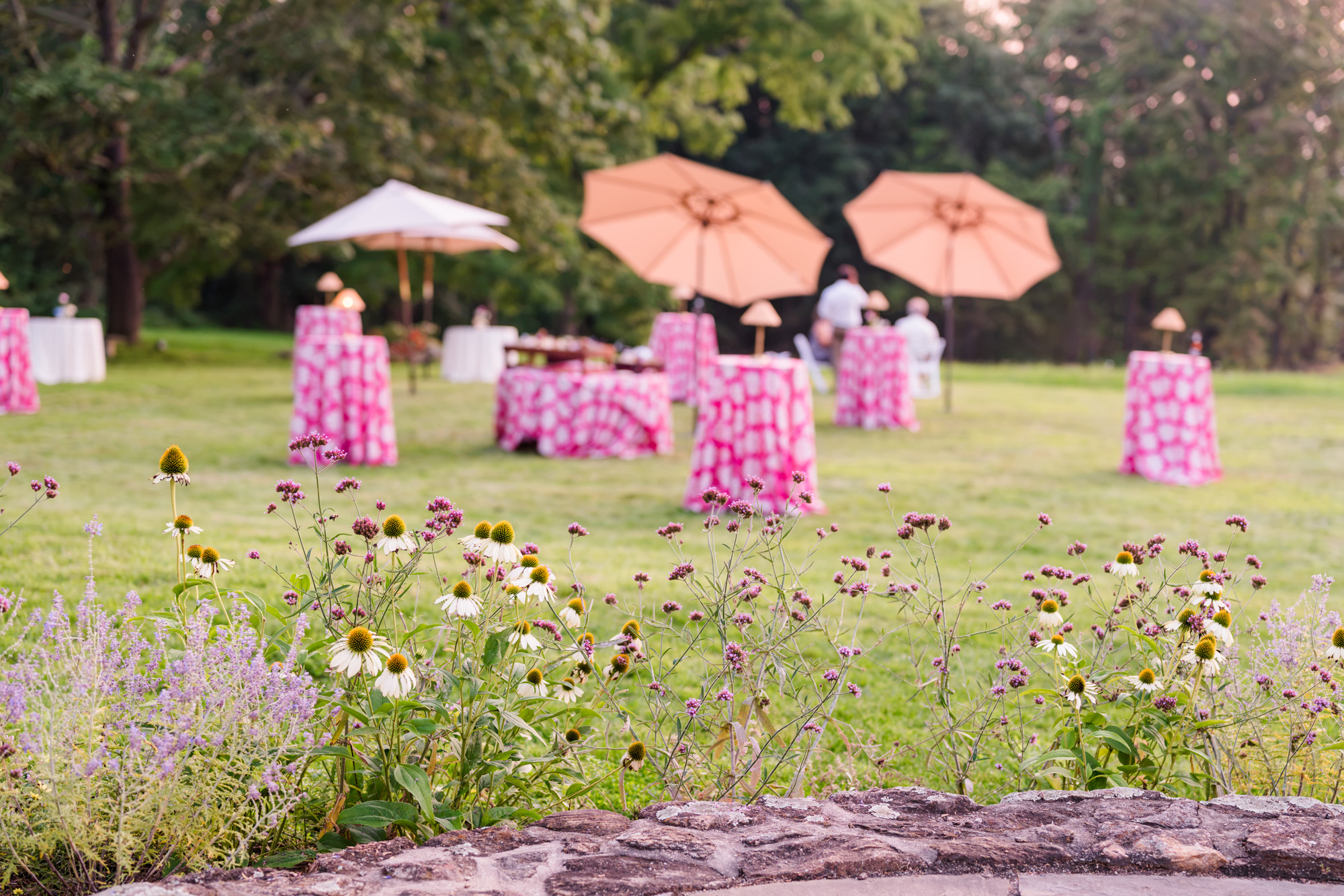 Colorful outdoor cocktail hour setup with pink linens and summer flowers in Pawling NY
