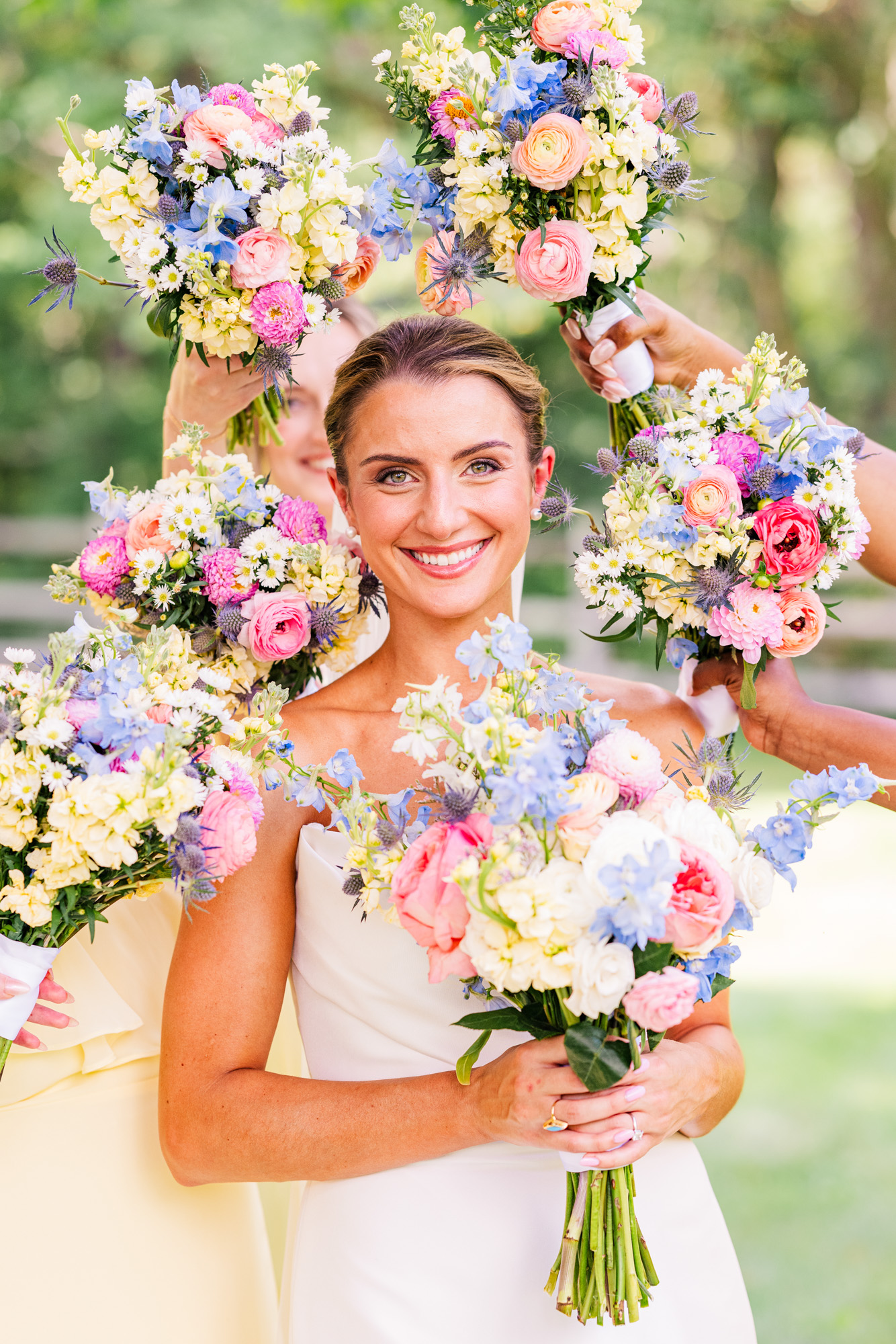 Smiling bride surrounded by colorful summer wedding bouquets in Pawling NY