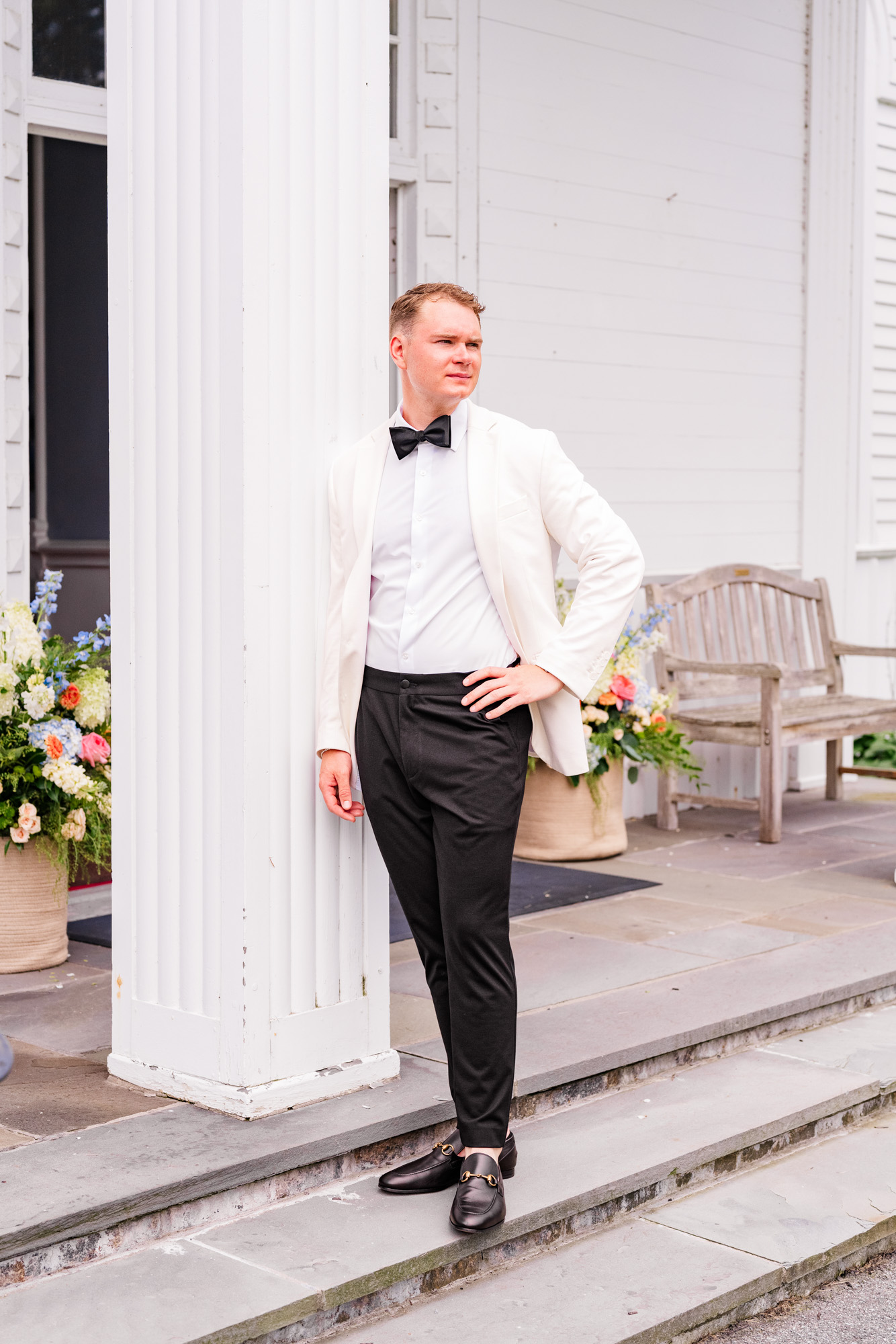 Groom leaning on pillar of Christ Church on Quaker Hill