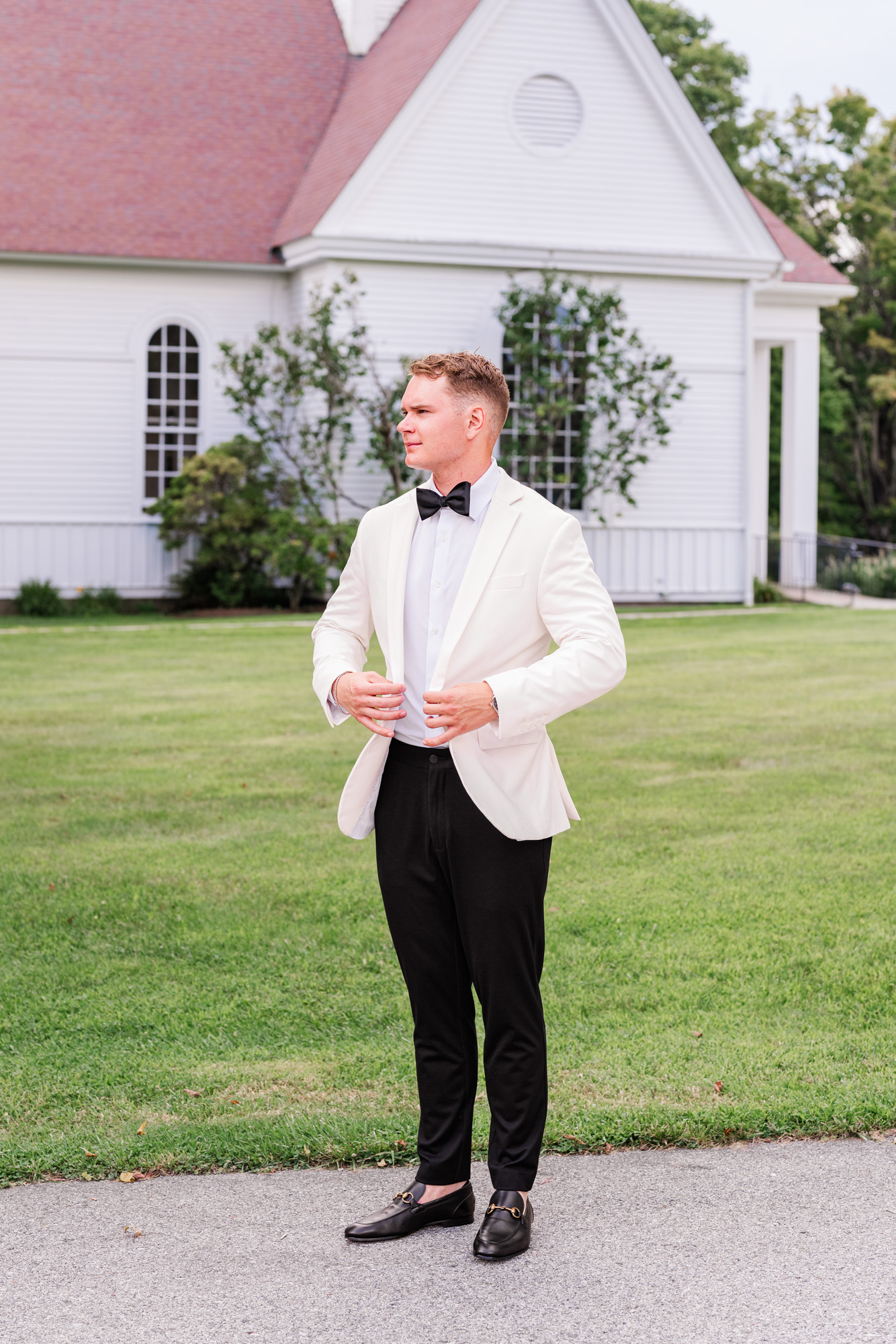 full length picture of groom with Christ Church on Quaker Hill