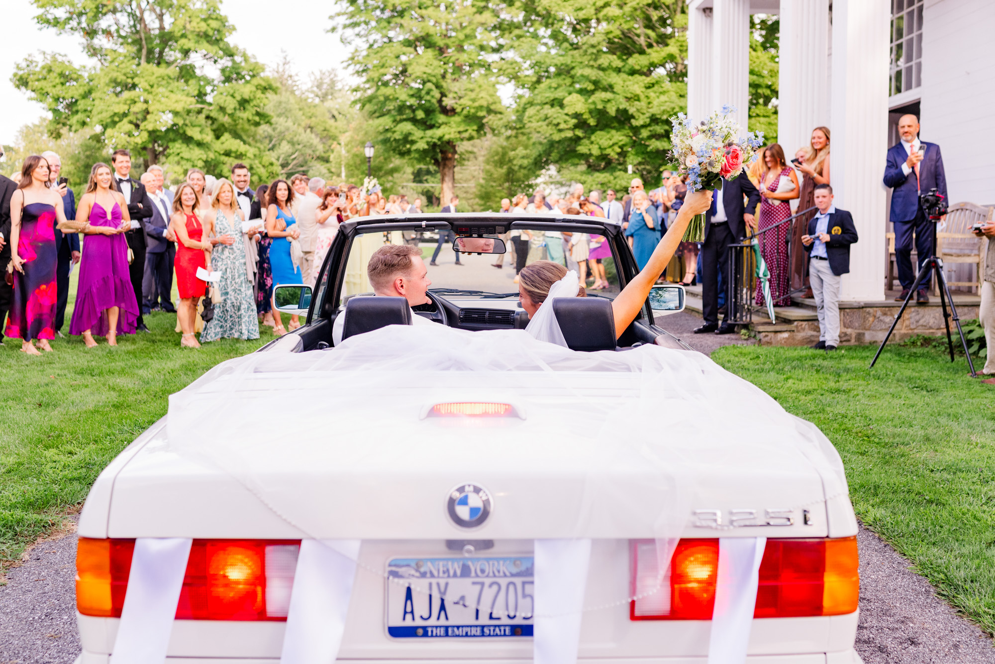 couple celebrating in BMW getaway car after their Pawling, NY ceremony