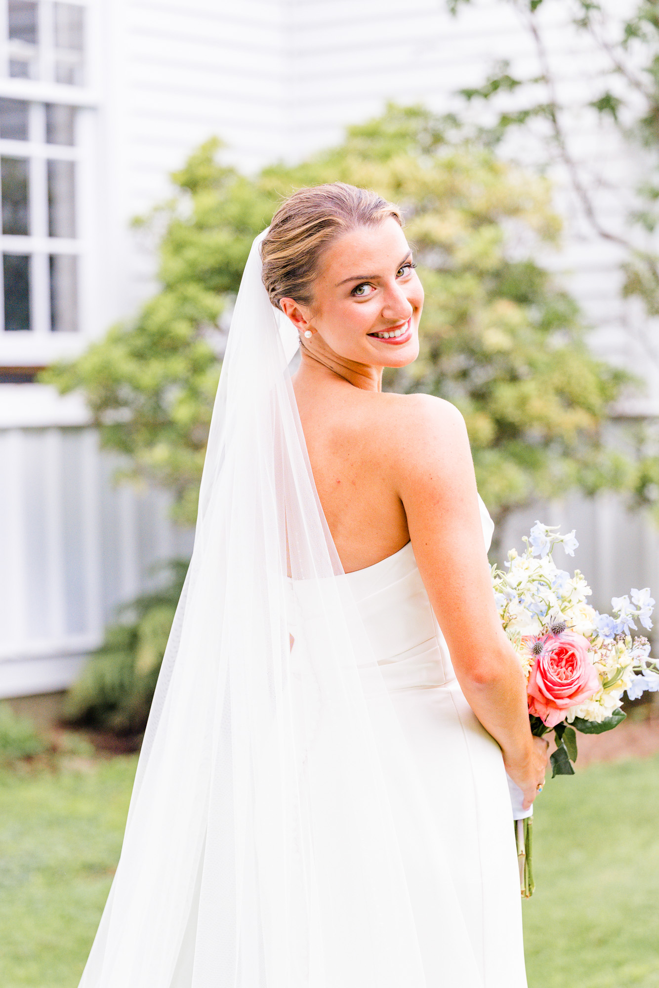 bride looking over her shoulder right before her first look