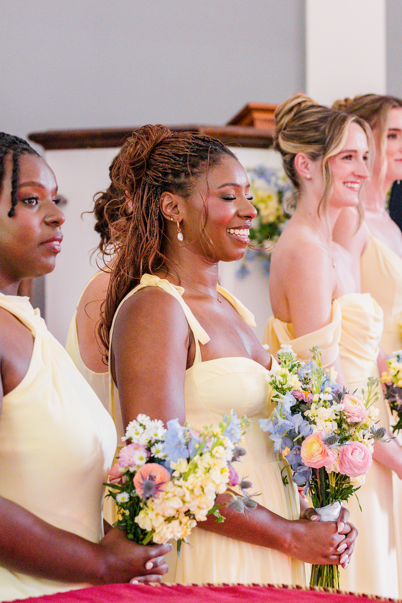 bridesmaid in yellow smiling during ceremony