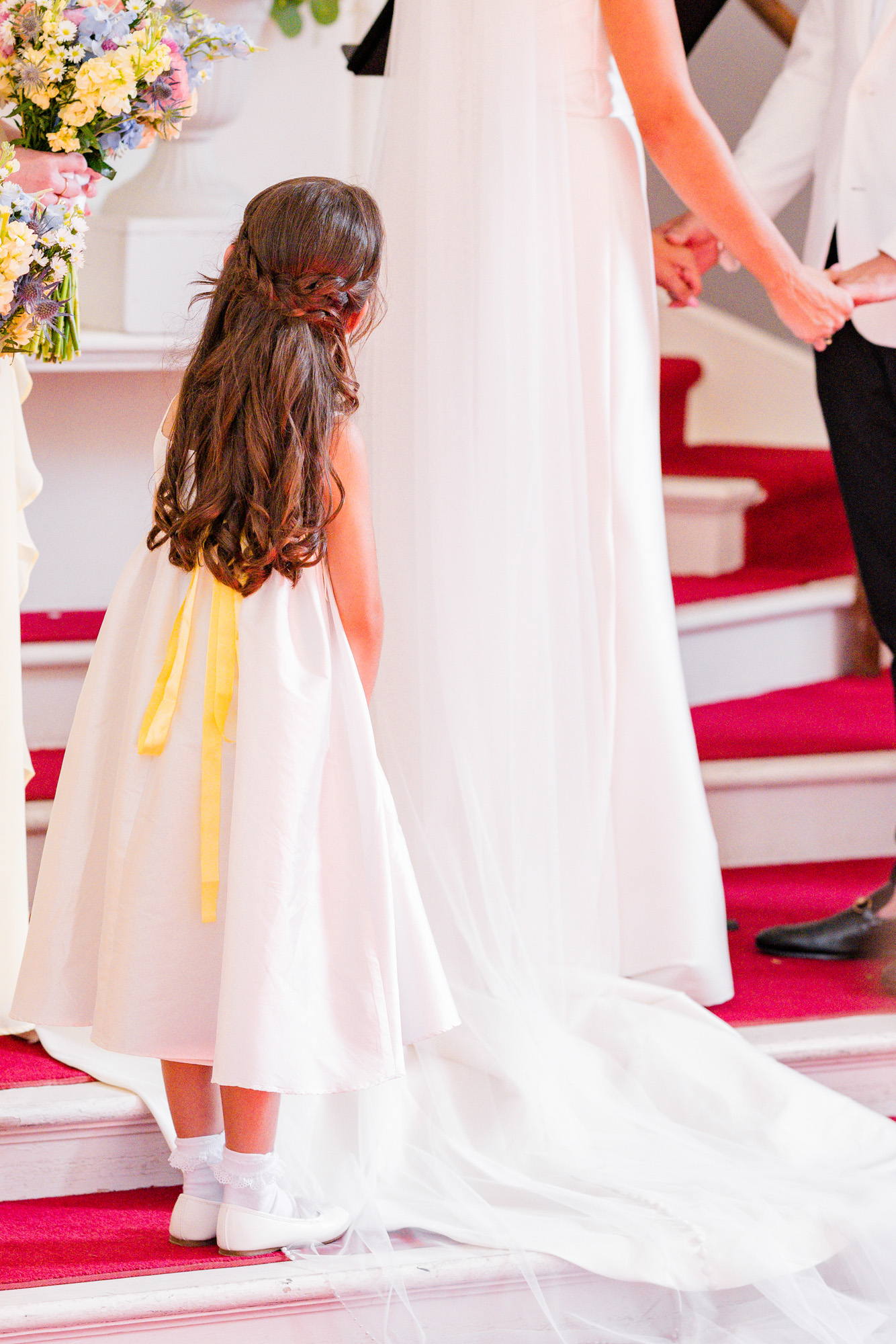 flower girl looking at bride during ceremony