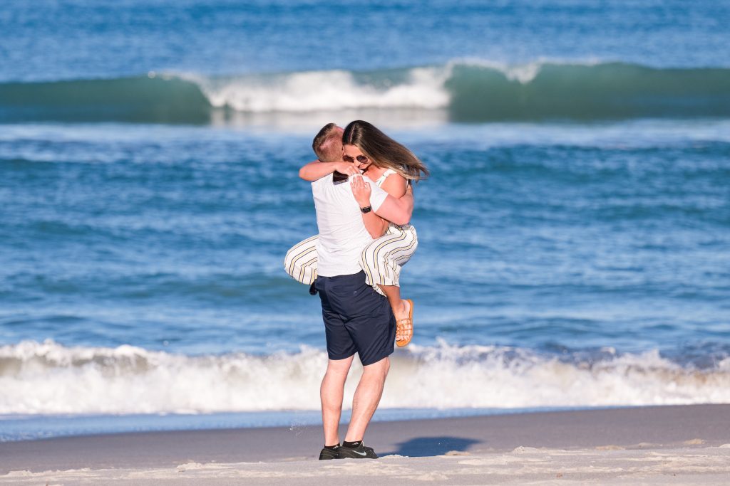 woman in the arms of a man after he proposed on melbourne beach florida