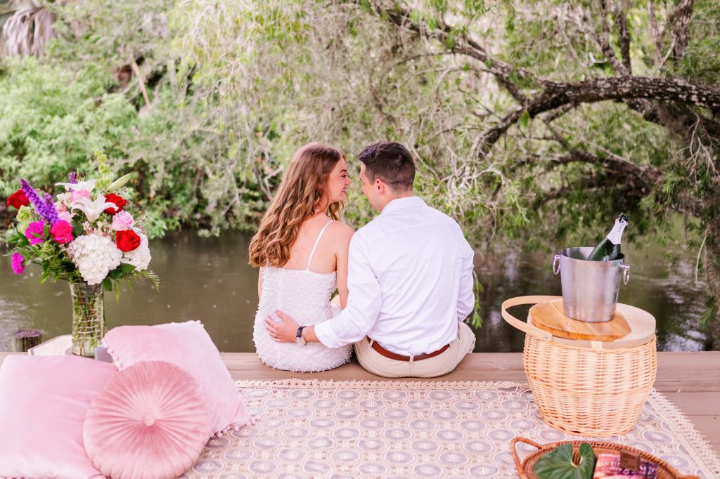 man and woman sitting by river right after wedding proposal at up the creek farms