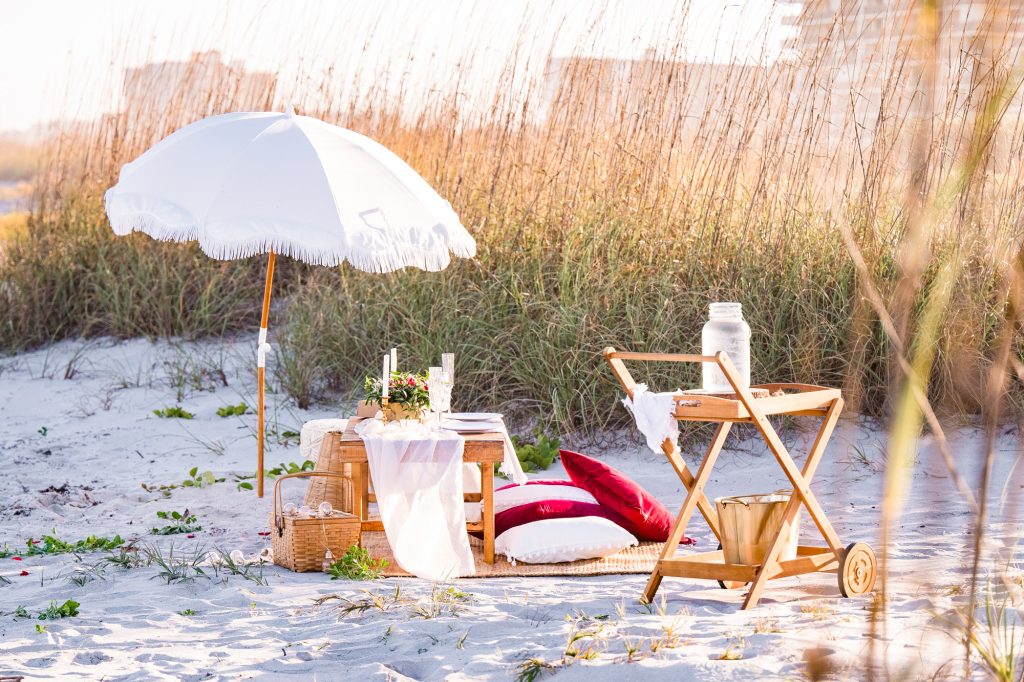 picnic setup with umbrella and champagne on cocoa beach