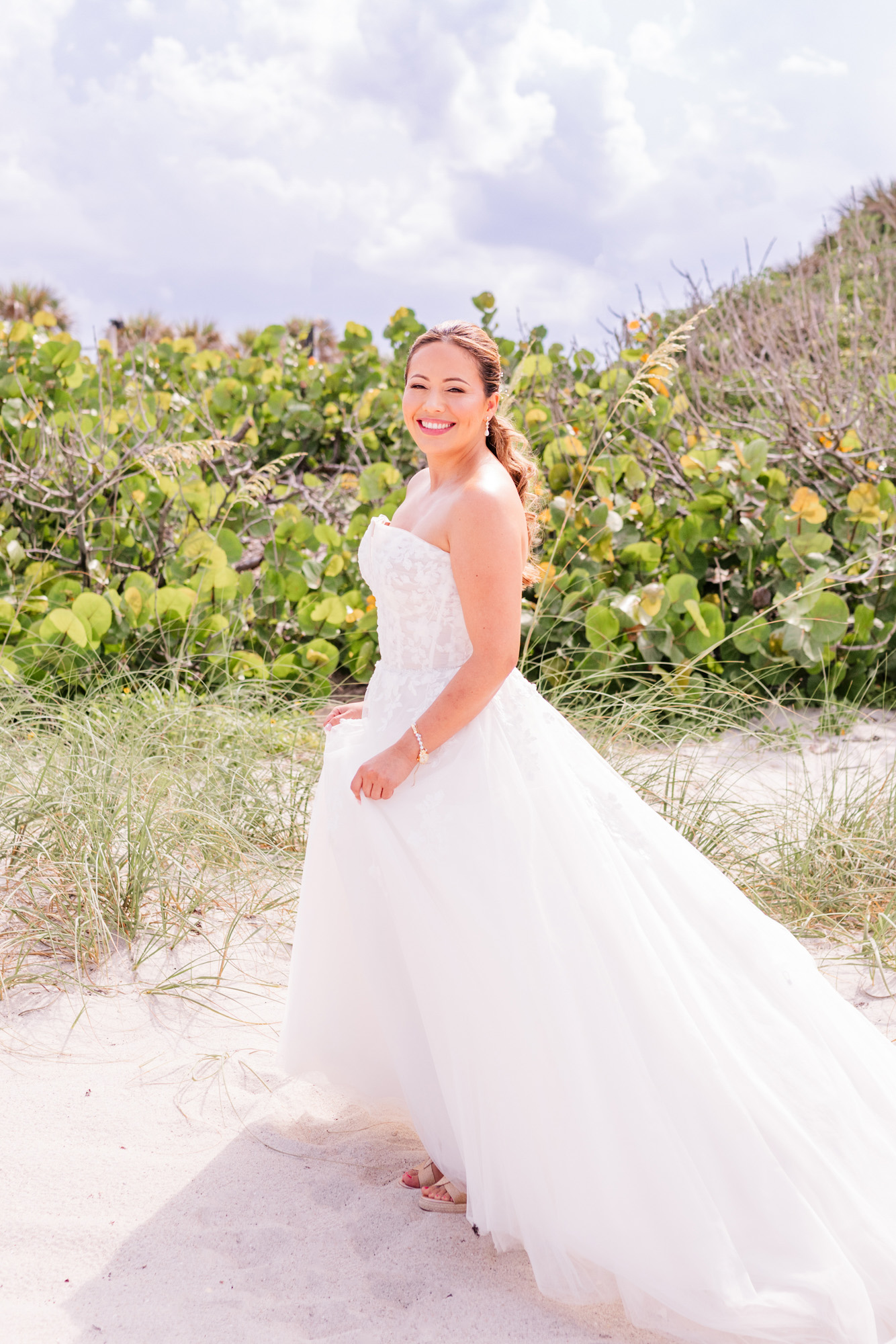 Bride posing by the dunes before a storm rolls in.