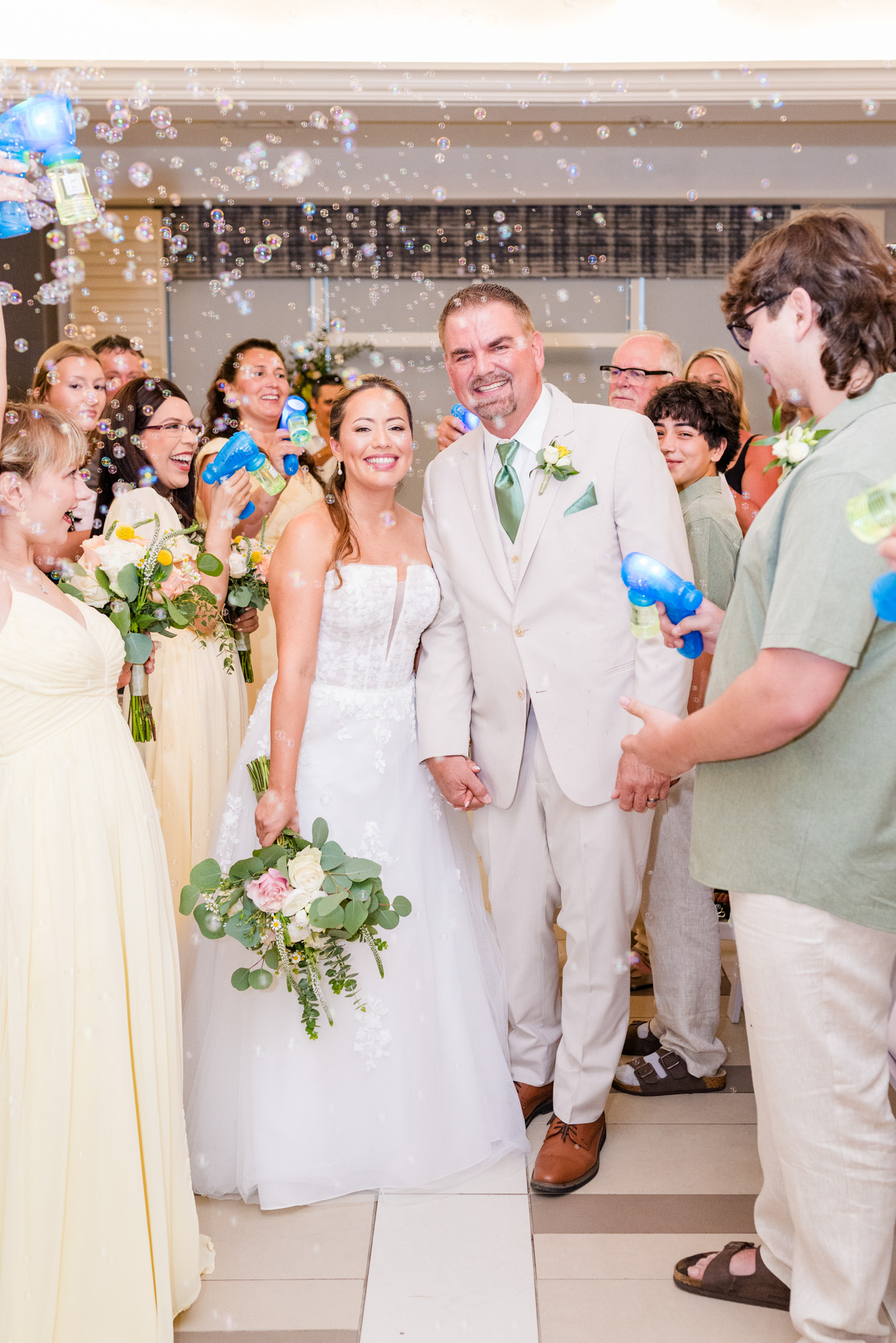 Couple exiting while guests blow bubbles