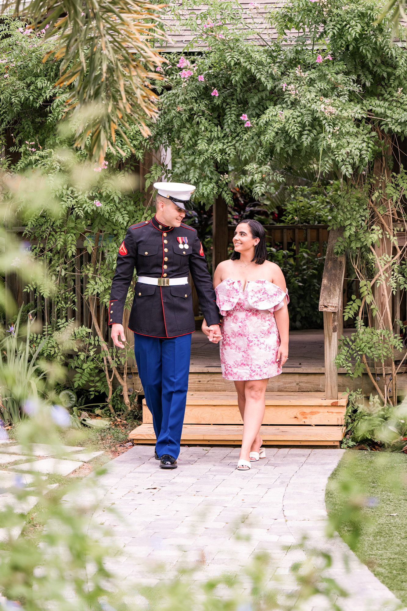 Man in uniform and woman in pink dress at their engagement session at Rockledge Gardens