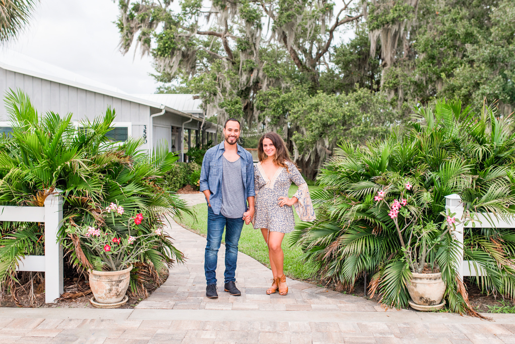 Man and woman holding hands at the entrance to Up the Creek Farms after their engagement session