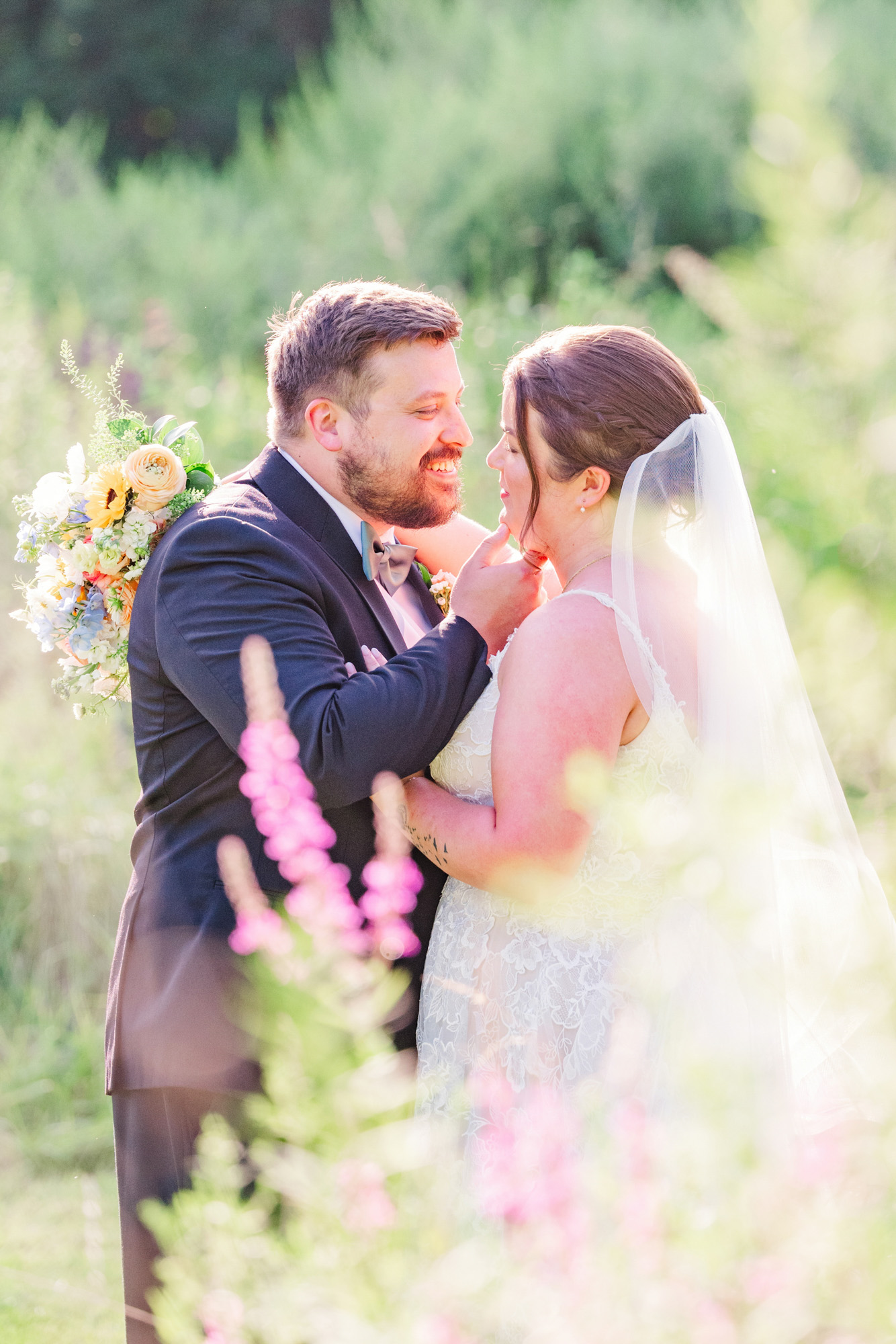 Groom gently touching his bride’s face during romantic outdoor wedding portraits.