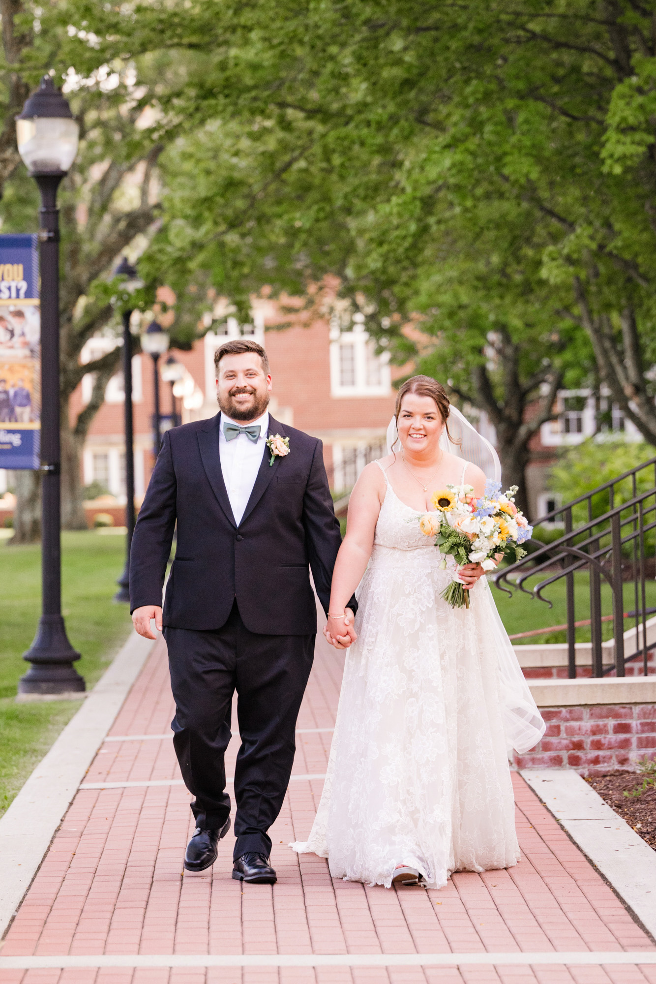 Bride and groom walking hand in hand along a brick path after their wedding.