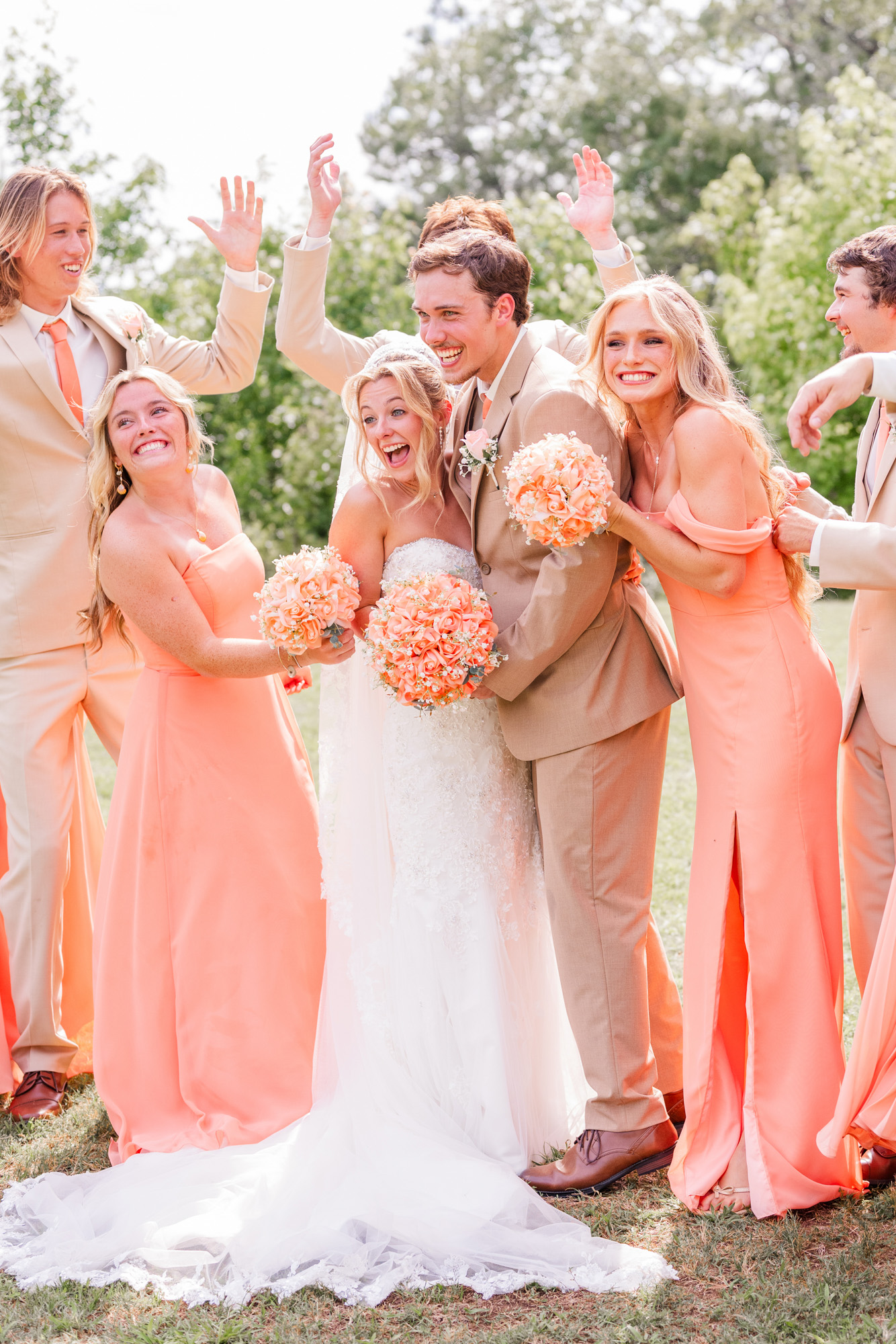 Bride and groom celebrating with their wedding party outdoors.