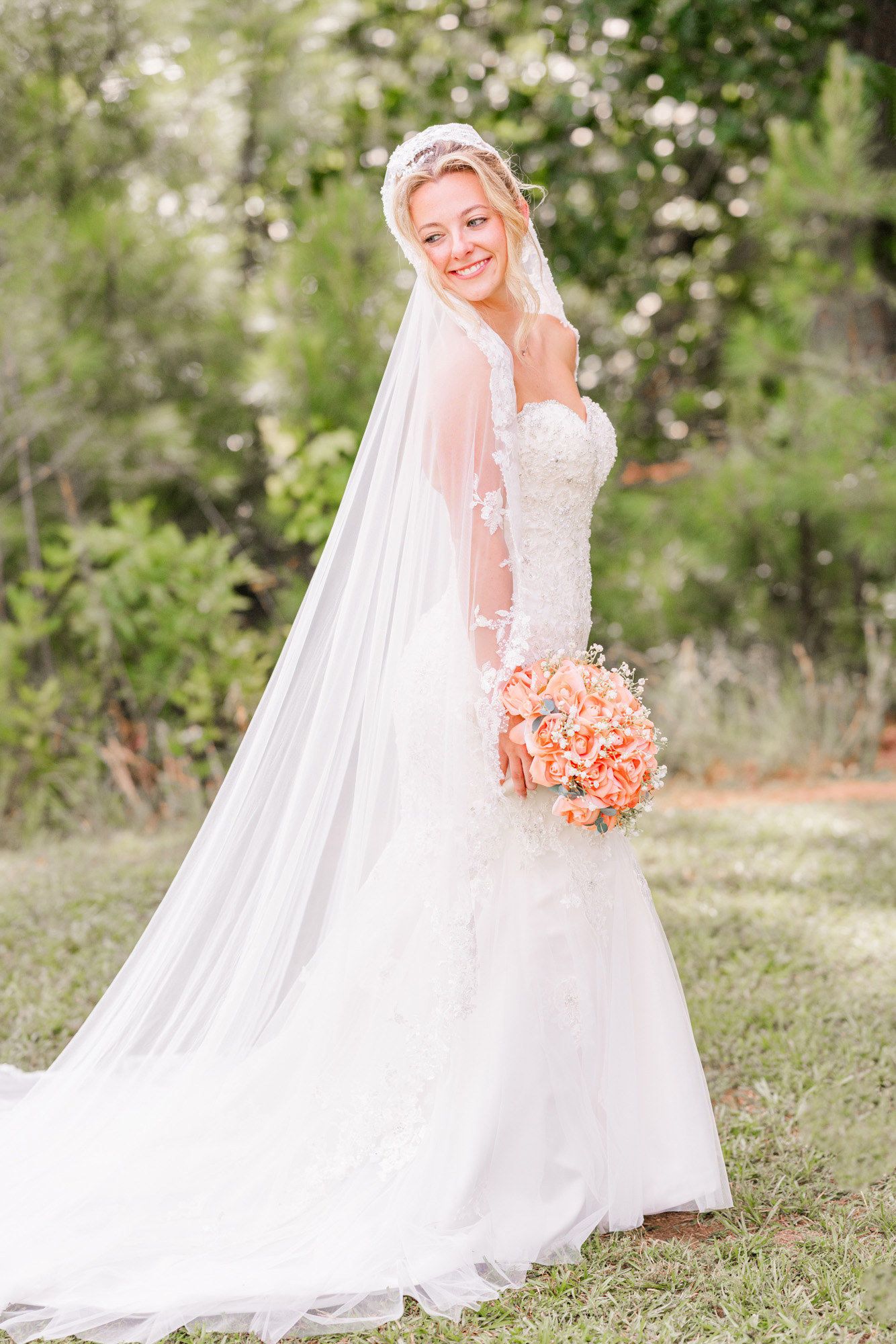 Bride showing off her long veil during an outdoor bridal portrait.