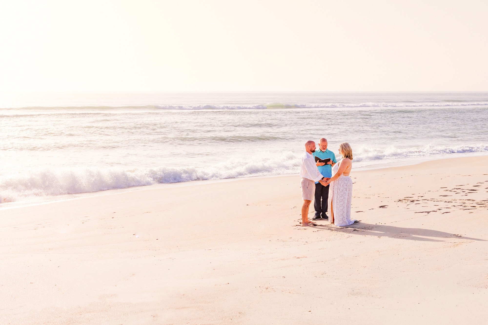 bride and groom on beach at sunrise saying vows during their elopement on Melbourne Beach