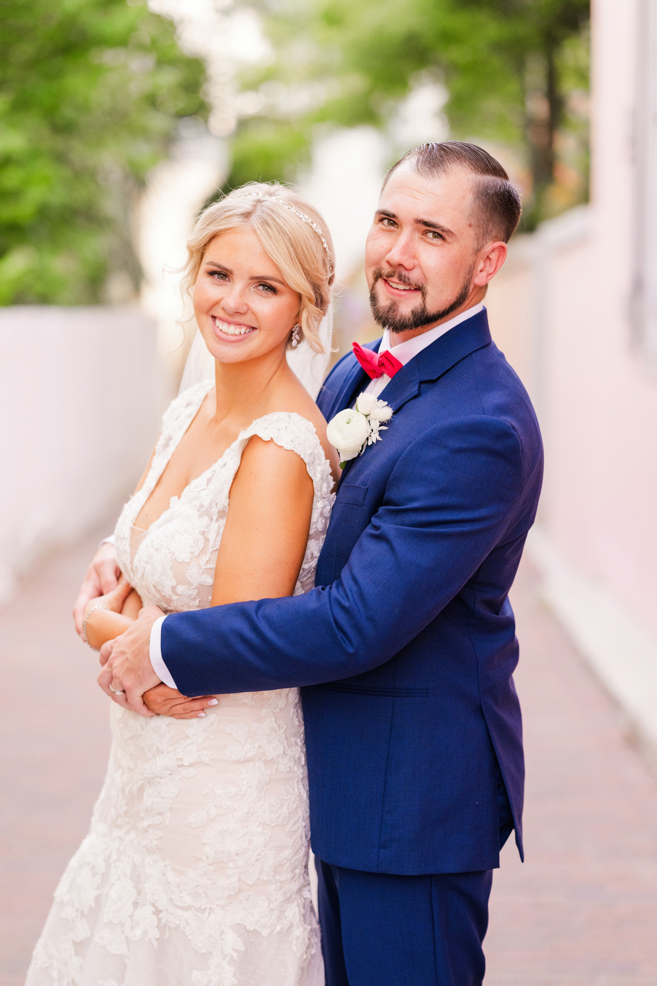Man in blue suit hugging wife in an alley in St. Augustine at The White Room