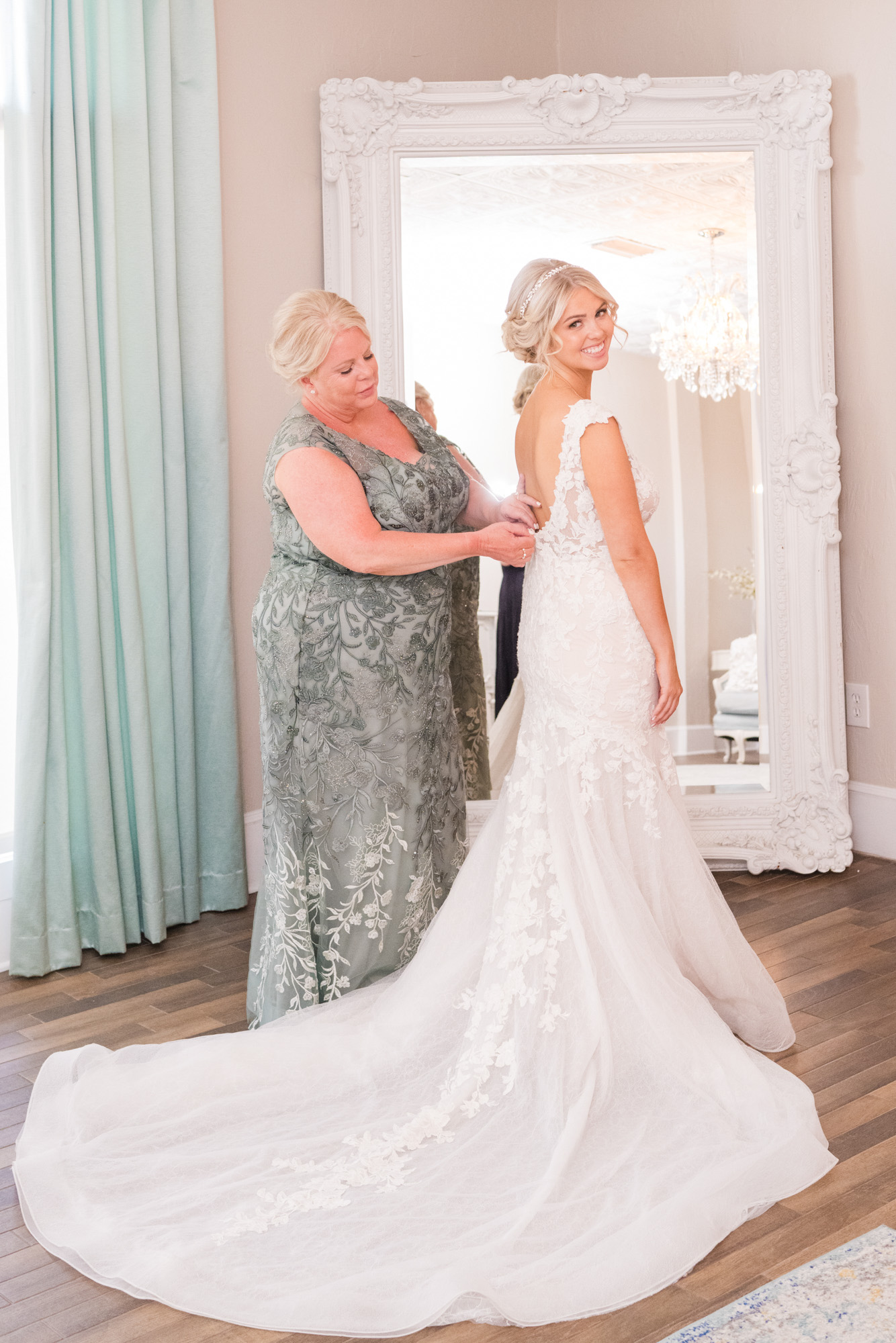 mother of the bride zipping up her dress at The White Room