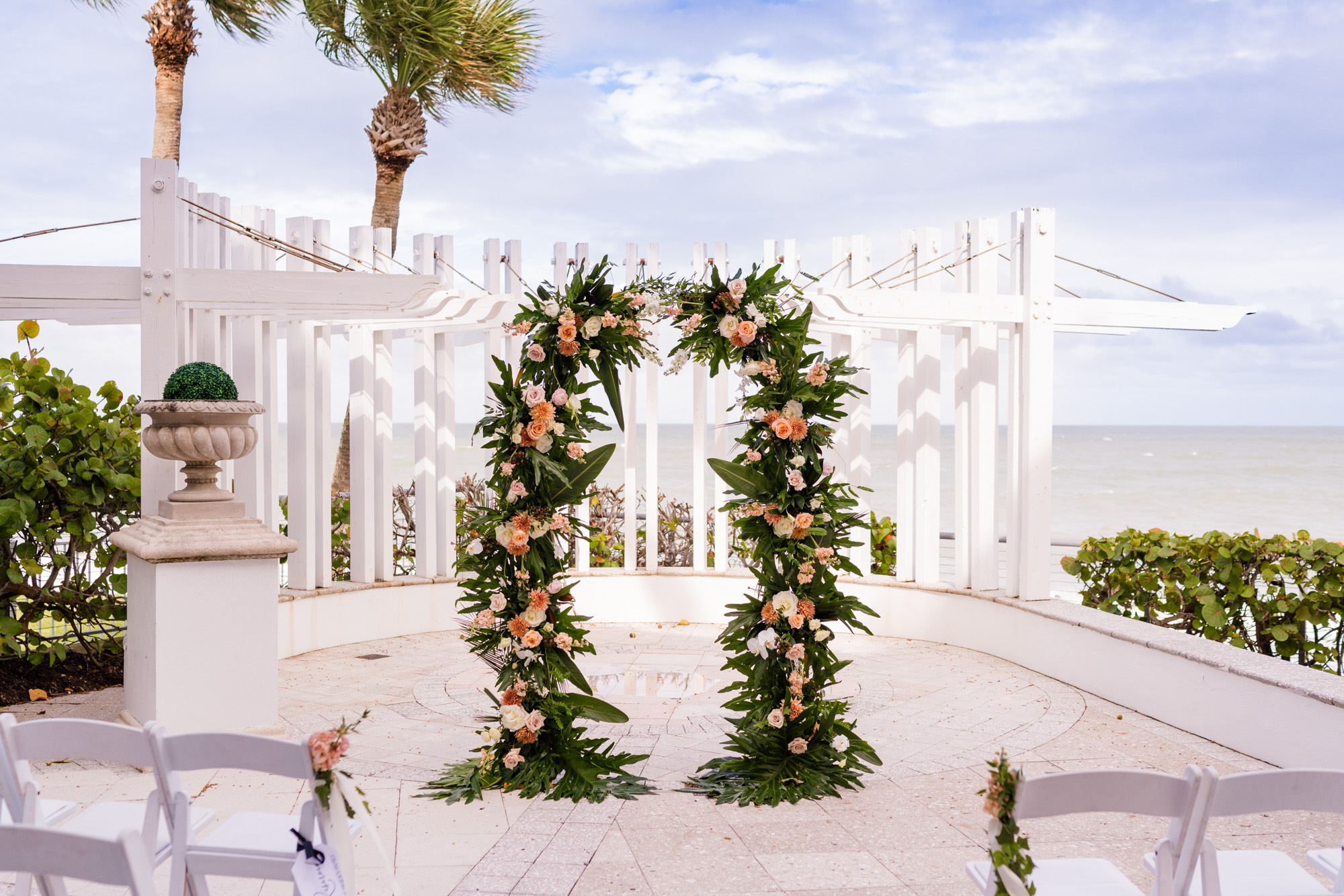 Oceanfront wedding ceremony setup with a lush floral arch at Vero Beach Hotel & Spa in Florida.