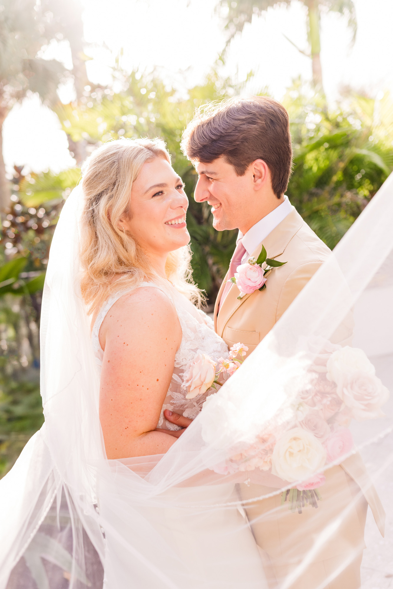 Bride and groom smiling together in soft backlight during their Vero Beach wedding portraits.