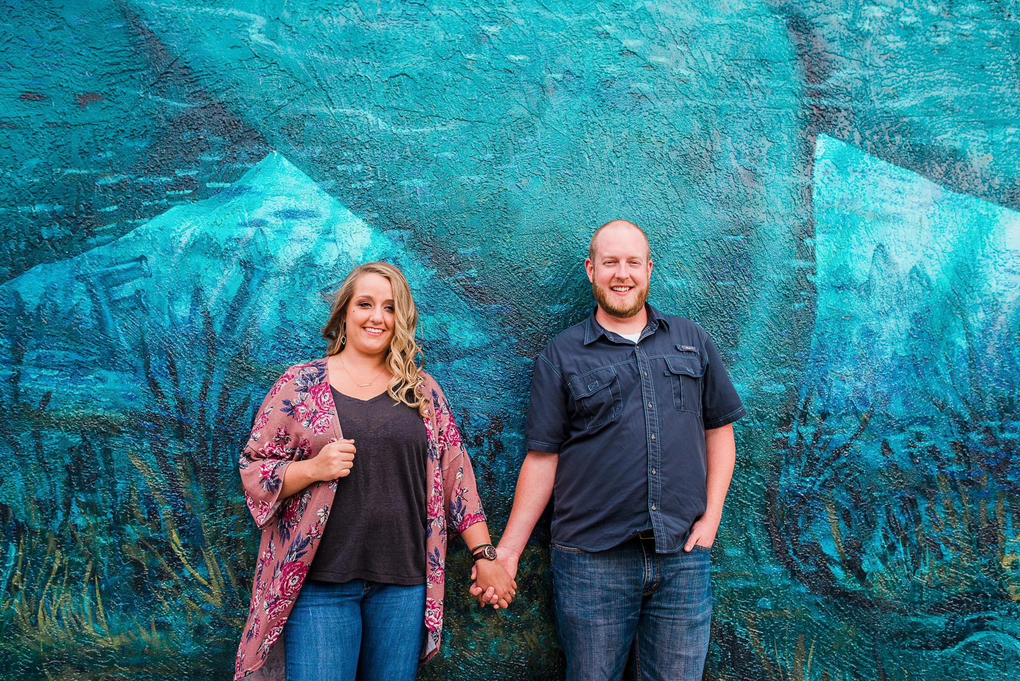 couple holding hands in front of big mural in downtown Melbourne