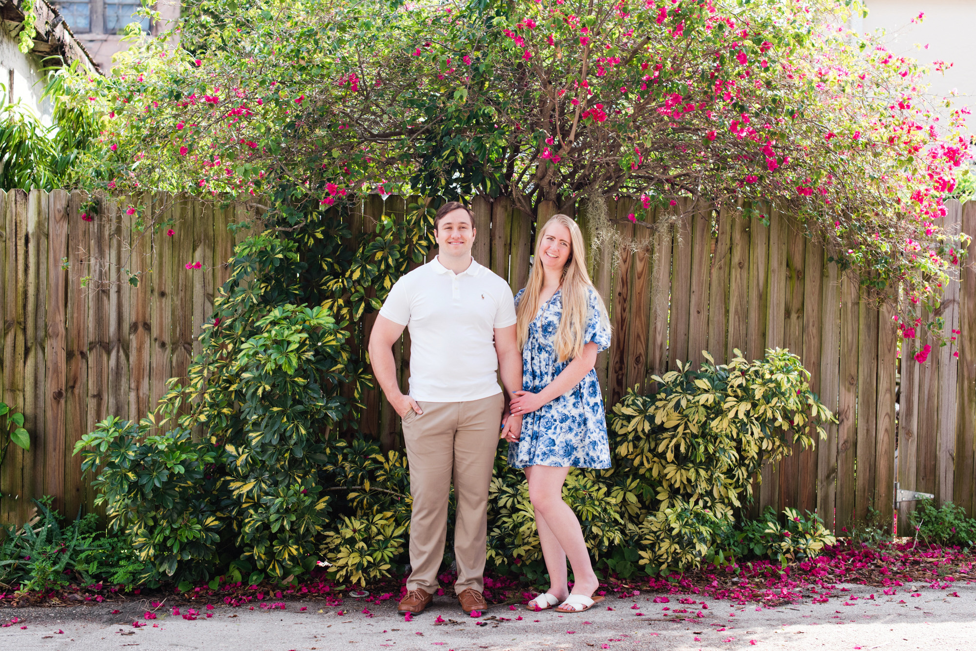 couple holding hands in front of bush in the Eau Gallie Arts District
