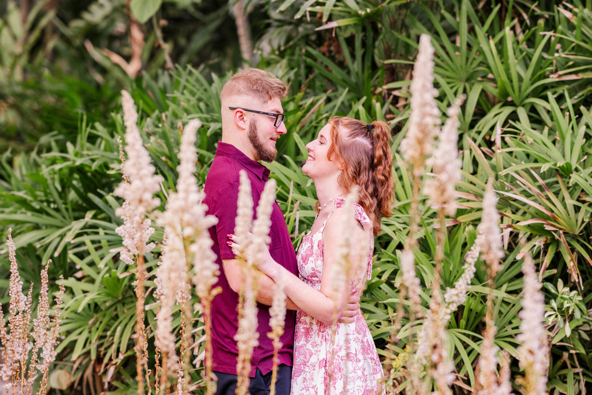 Man in red shirt looking at woman through the plants at Florida Tech